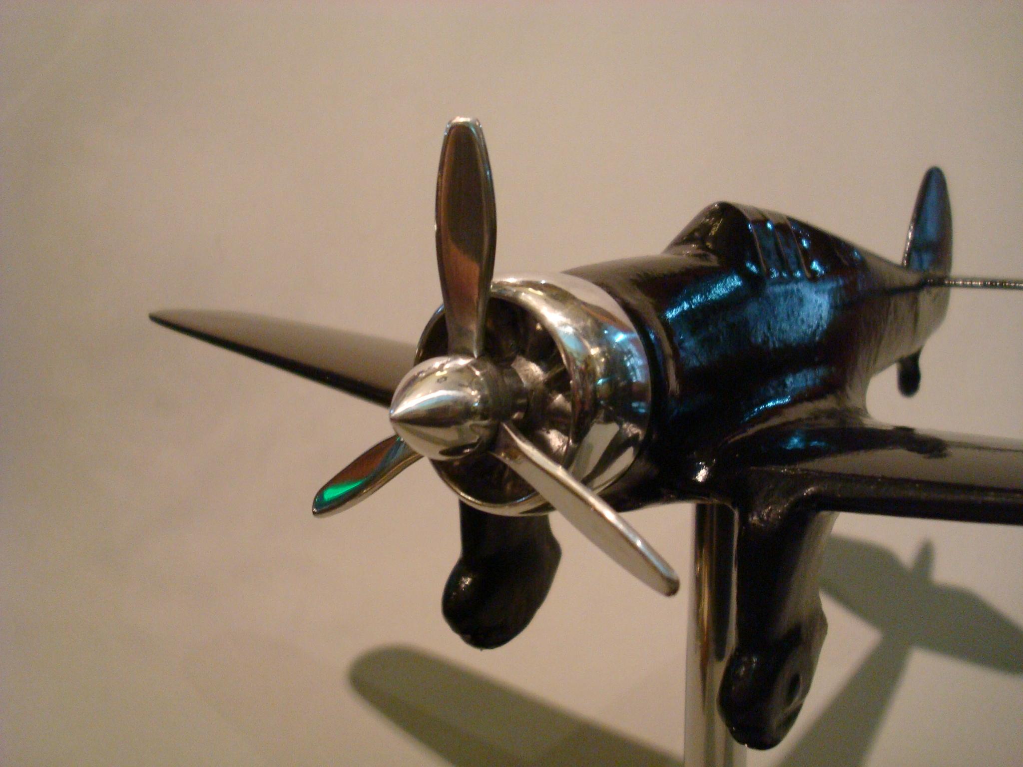 Airplane fighter desk stand model, 1930s.
Made of polished aluminium and painted black over the body, mounted over a black wooden base. Very nice Aviation collectable.

 