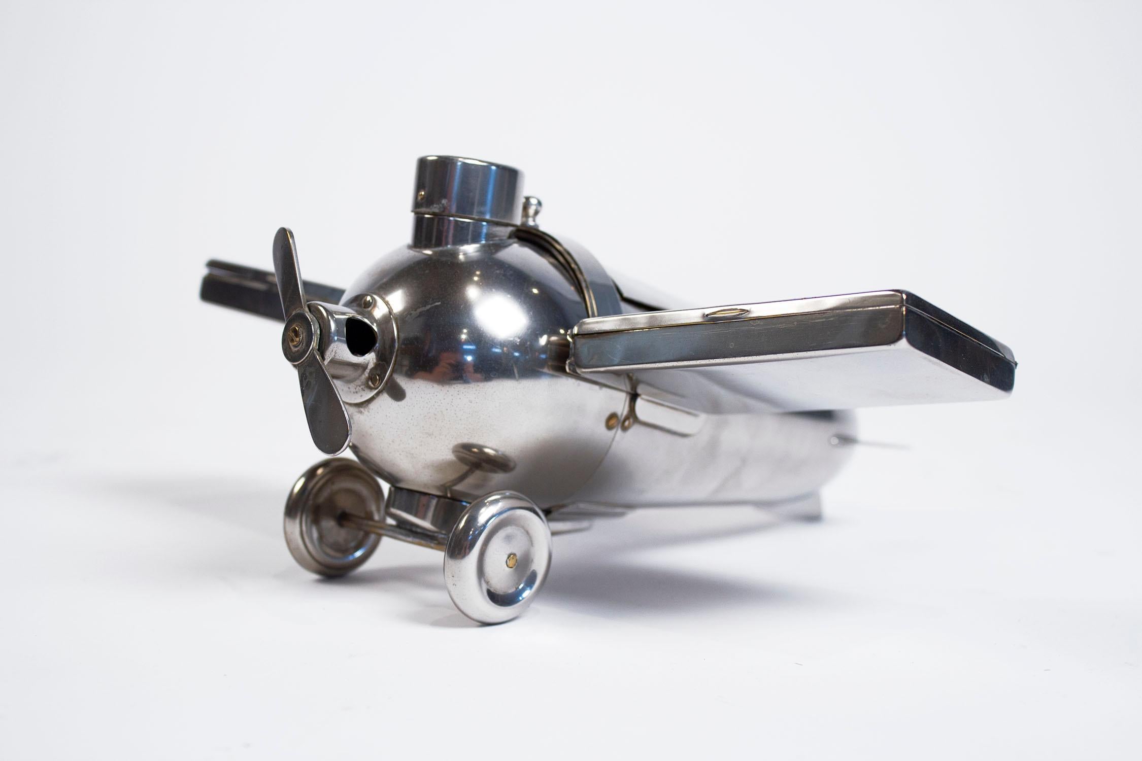 Airplane smokers companion set, silver-plated brass, circa 1930 by J.A. Henckels, Germany. The body of the plane has a hinged cover for cigars or pipe tobacco, or medicinal marijuana,  the detachable wings are cigarette cases, the wheels are a pipe