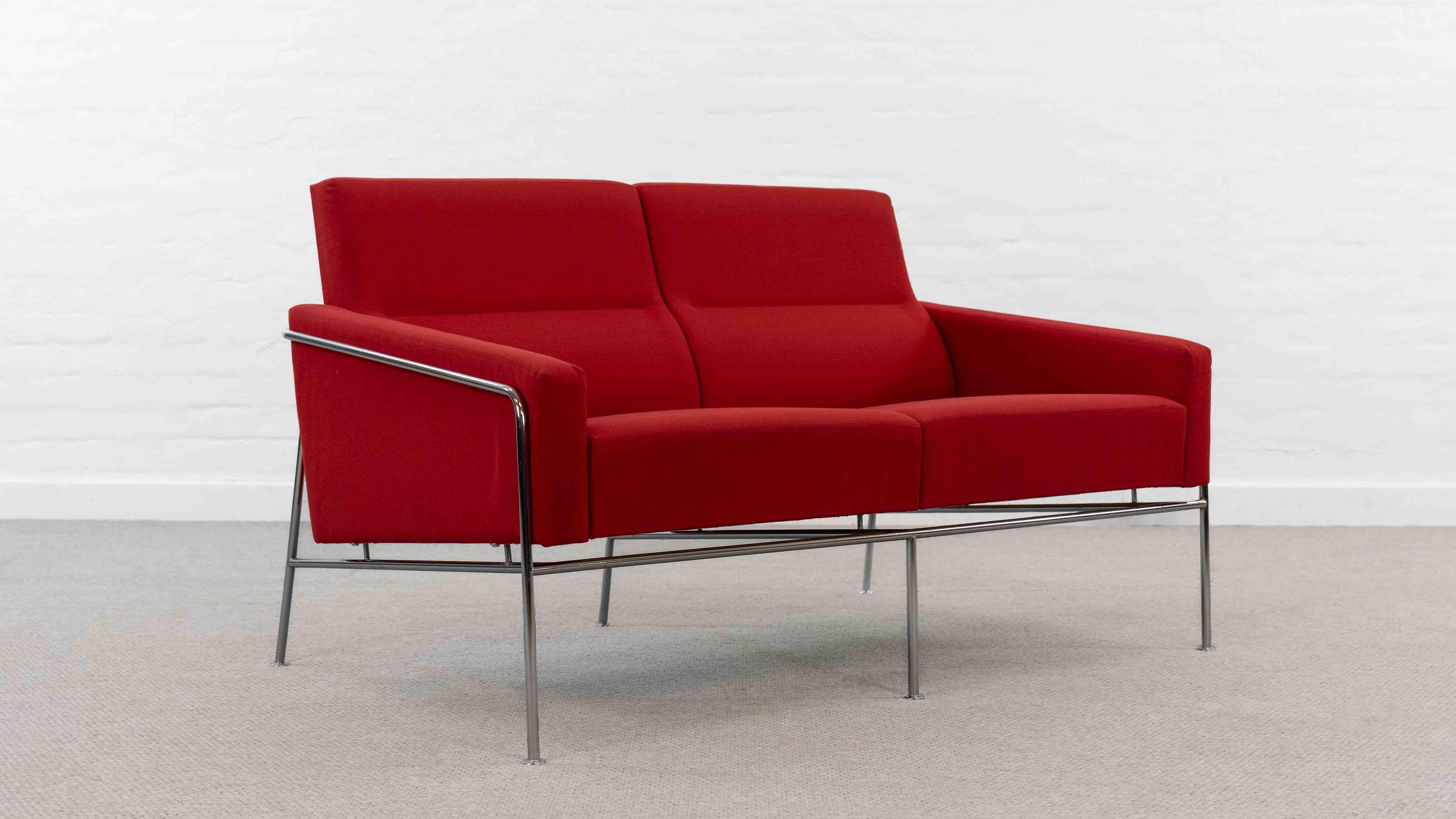 So-called Lufthavn sofa / Airport sofa, designed in 1957 by Arne Jacobsen for SAS Royal. Model 3300/2, 2002 edition. Upholstered with original red fabric. Good used condition. Small stain on the front left, as well as minimal imperfections on the