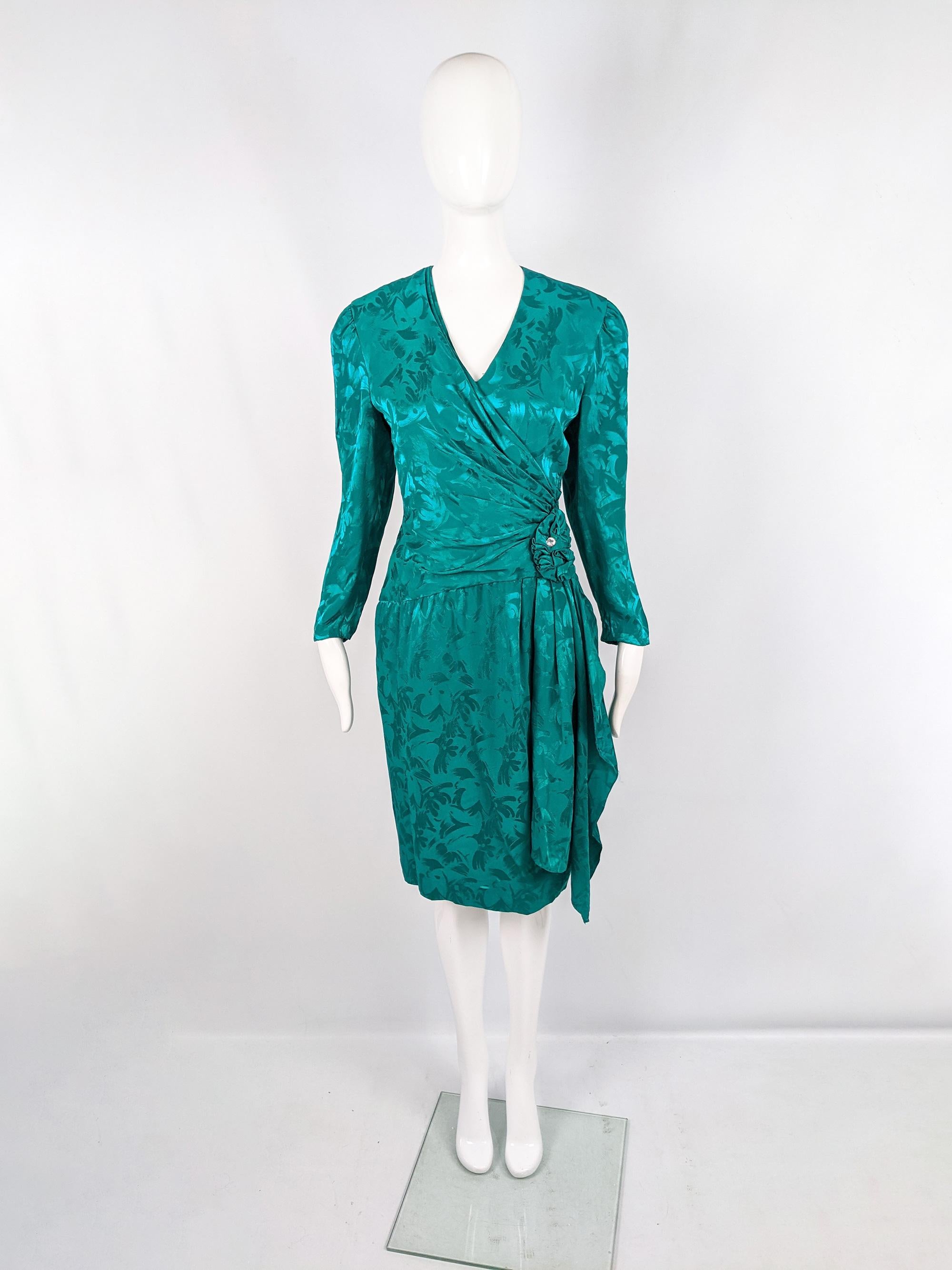 A fabulous vintage womens evening dress from the 80s by quality American designer, A.J Bari. In an emerald green pure silk fabric with a satin jacquard pattern woven throughout. It has a crossover front, ruched detail at the side with a single