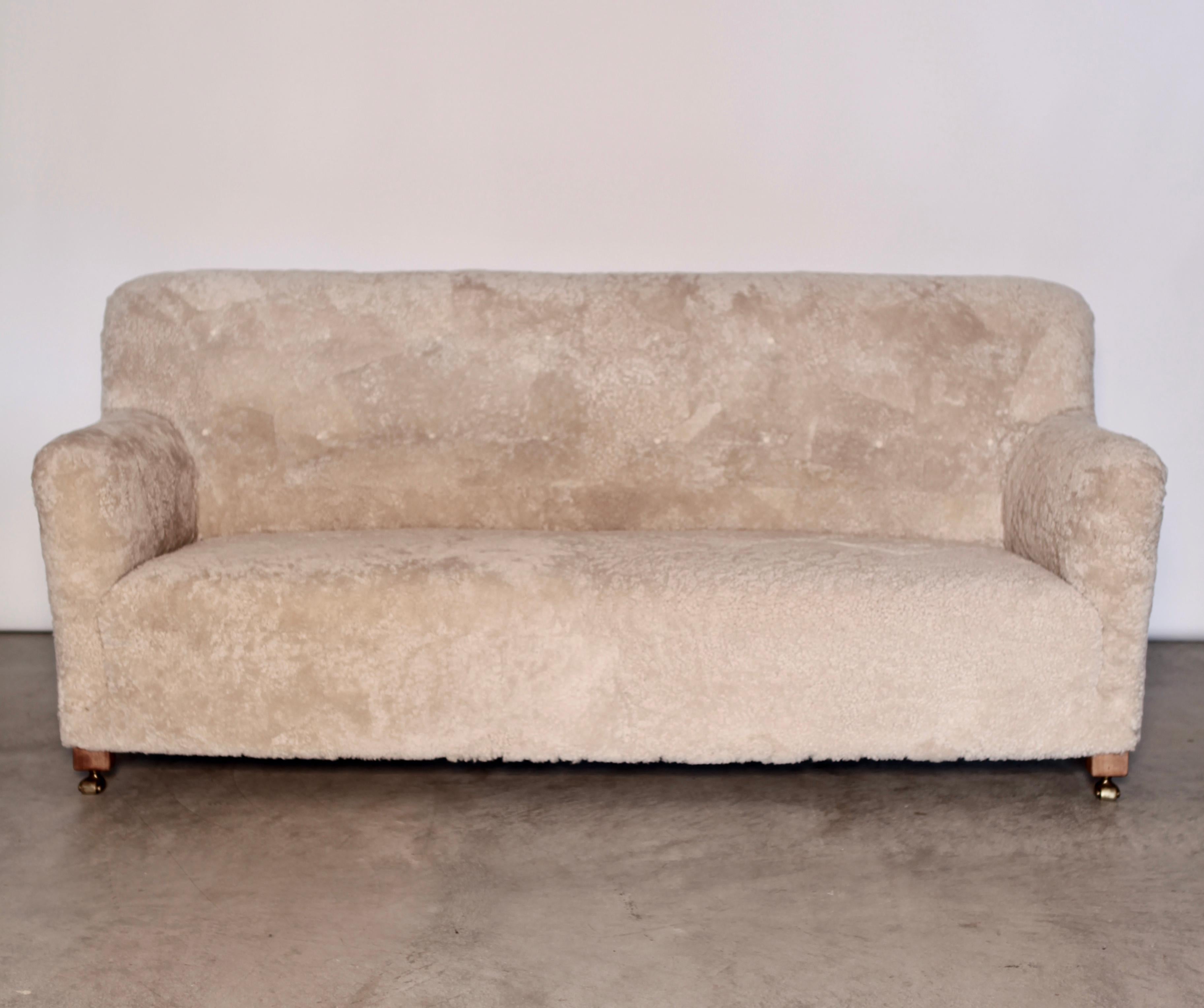 Sofa by master cabinetmaker Andreas Jeppe Iversen (1888-1979) Denmark
Stained beech legs, front legs on brass castors
Designed and manufactured, 1939
New authentic Lambskin upholstery, back fitted with buttons
High backrest 

Andreas Jeppe