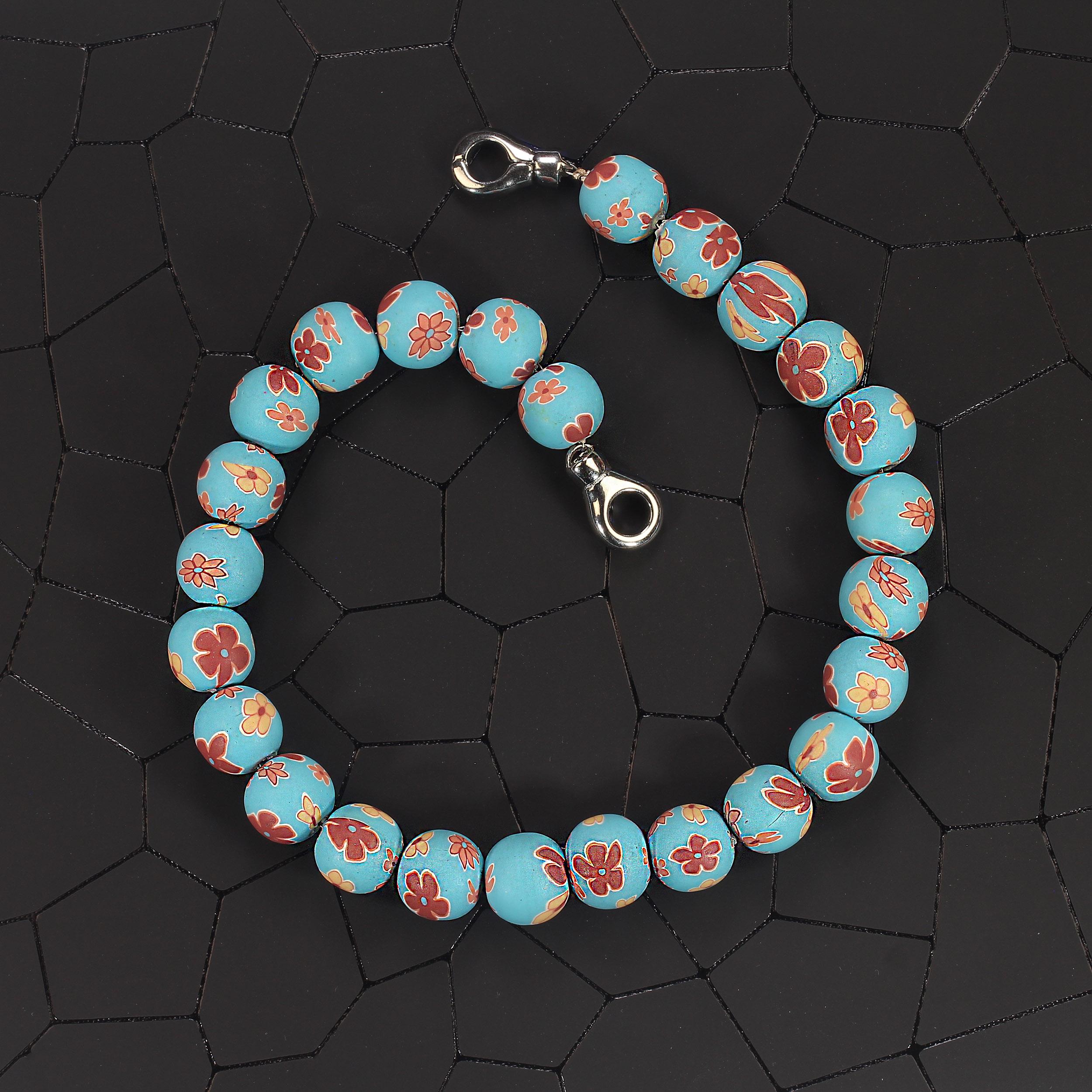 Questa elegante collana girocollo da 16 pollici è una straordinaria fusione di arte tradizionale e fascino moderno. È caratterizzato da perline cinesi in argilla polimerica, ciascuna ornata da intricati motivi floreali in un'armoniosa tavolozza di