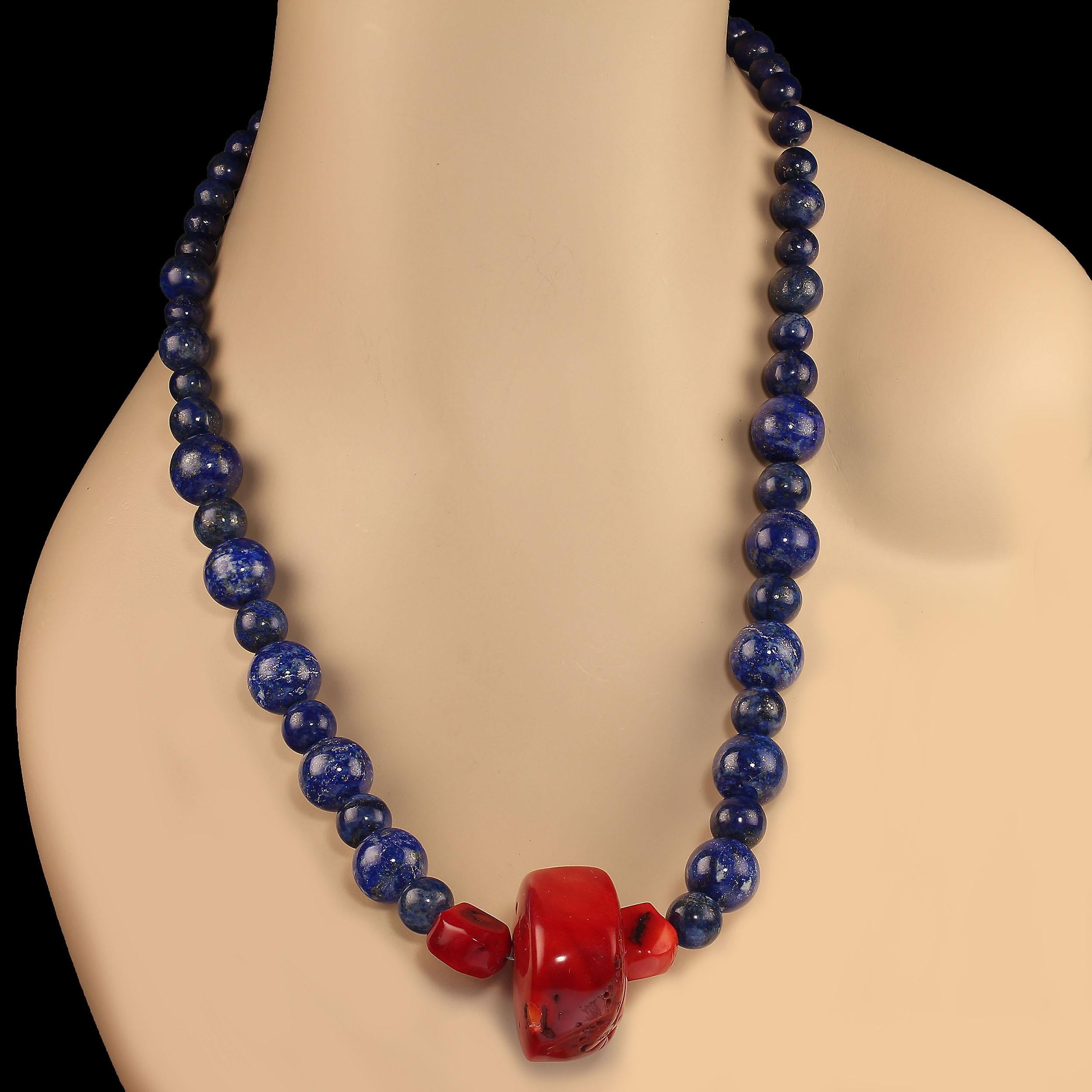 Statement necklace of gorgeous blue lapis lazuli in three sizes of smooth round beads in 14, 10, and 8 MM.  The red bamboo coral focal features a large roundish 35mm piece accented with two smaller pieces. This 23-inch necklace is secured with a