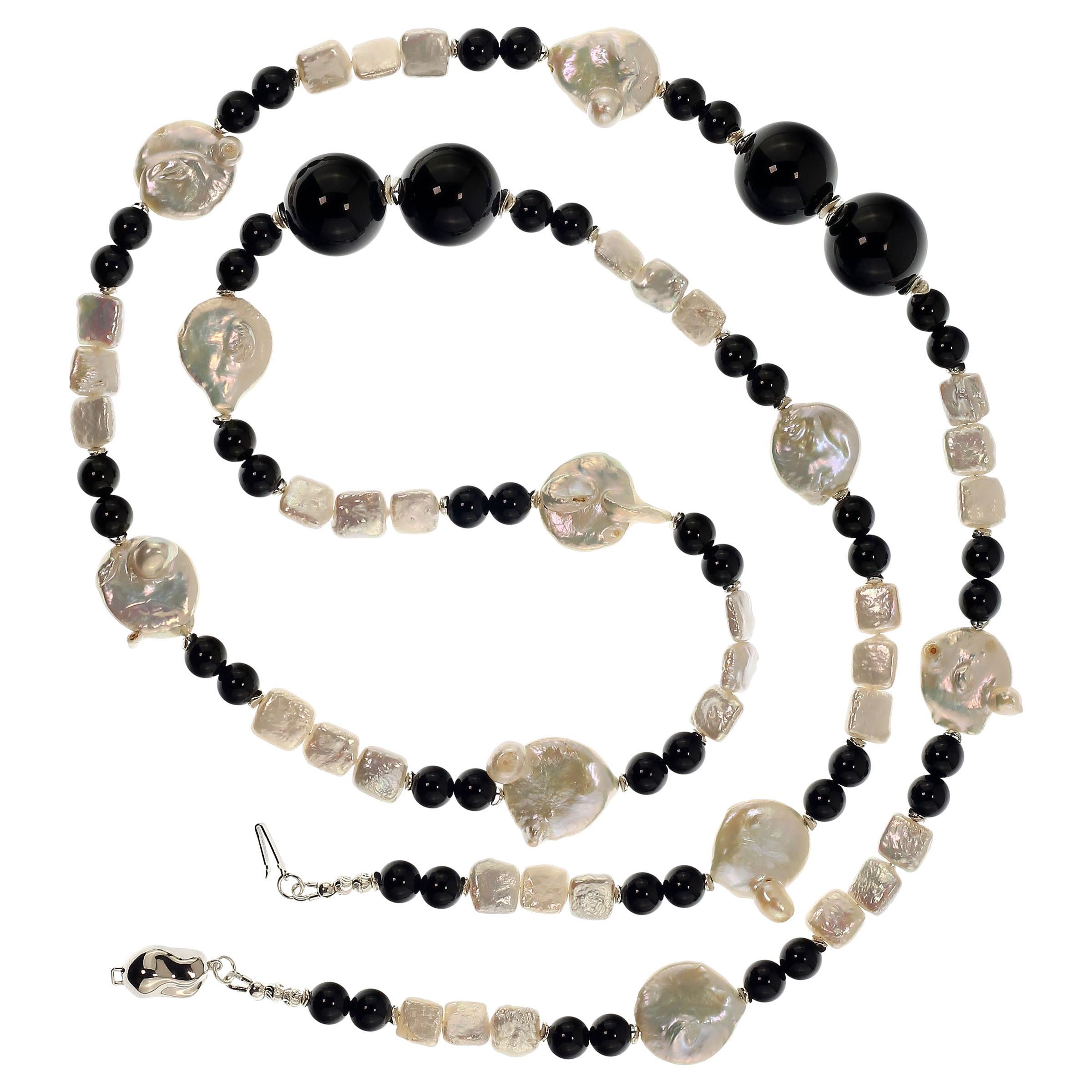 This is a lovely, long white Coin Pearl and Black Onyx necklace that is a pleasure to wear.  You can wear it long or double it.  It features white iridescent Coin Pearls, white square Pearls, and two sizes of highly polished smooth Black Onyx.  This