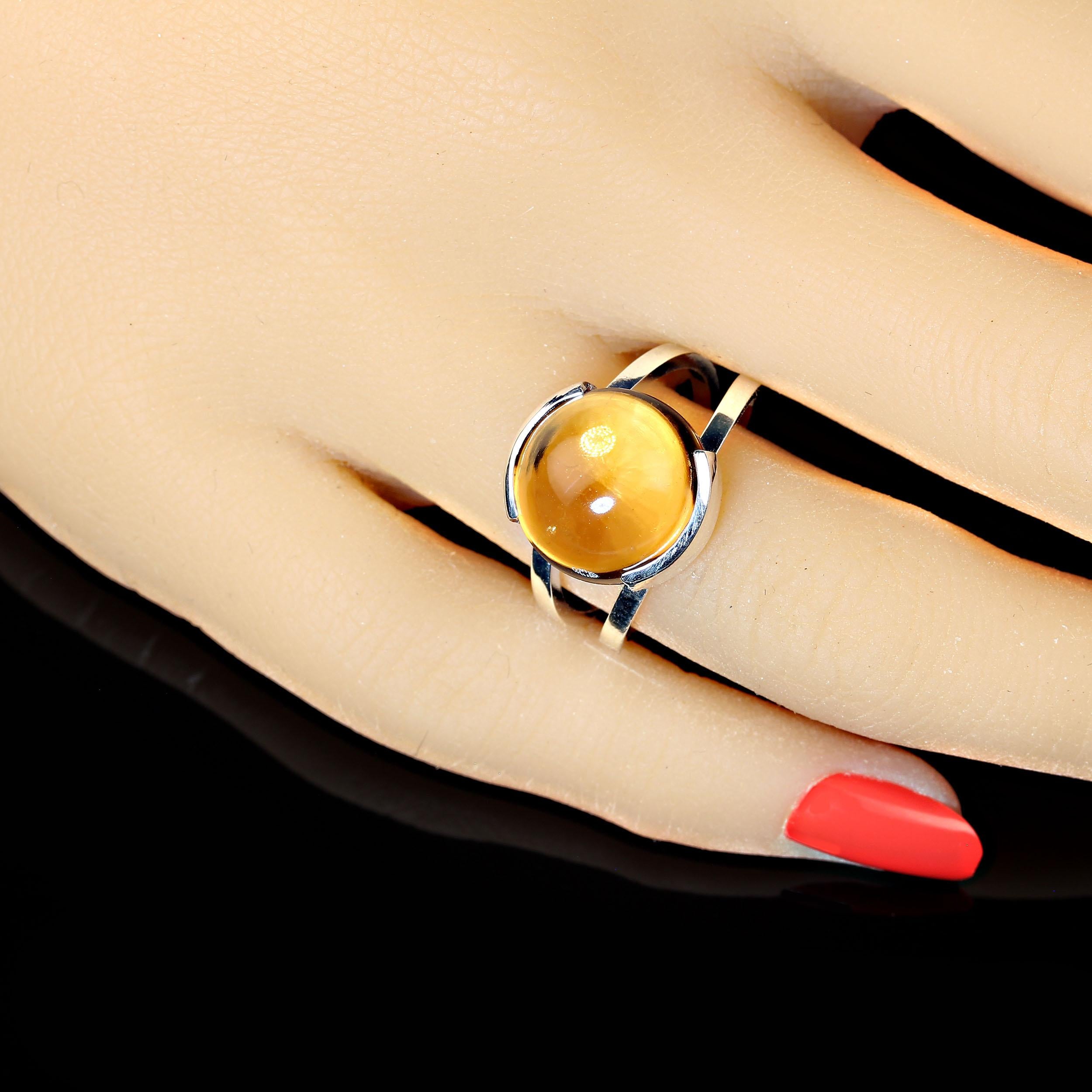 Smooth round 8.7 carat cabochon Citrine sitting in a half bezel setting.  The handmade Sterling Silver setting beautifully displays this unusual round cabochon gemstone. The setting is seated on a perfect split shank. The is a sizable 7.5. No