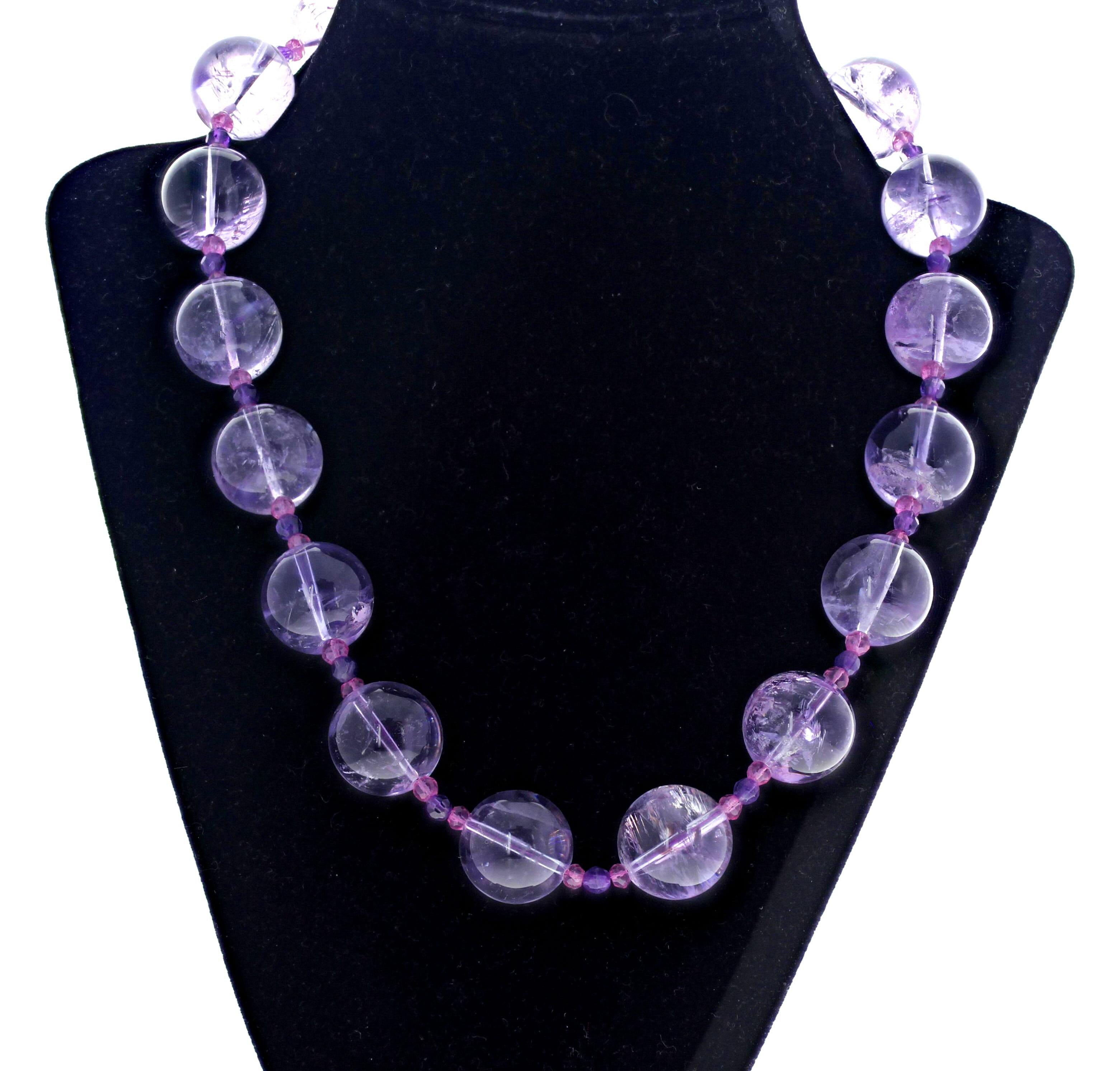 Diese lichtdurchlässigen, hellen, echten, runden, hochglanzpolierten Amethysten sind mit kleinen, dunklen, natürlichen Amethysten als Abstandshalter versehen. Die großen Amethyste sind ca. 18 mm rund und die kleinen, dunkleren Amethyste sind ca. 4