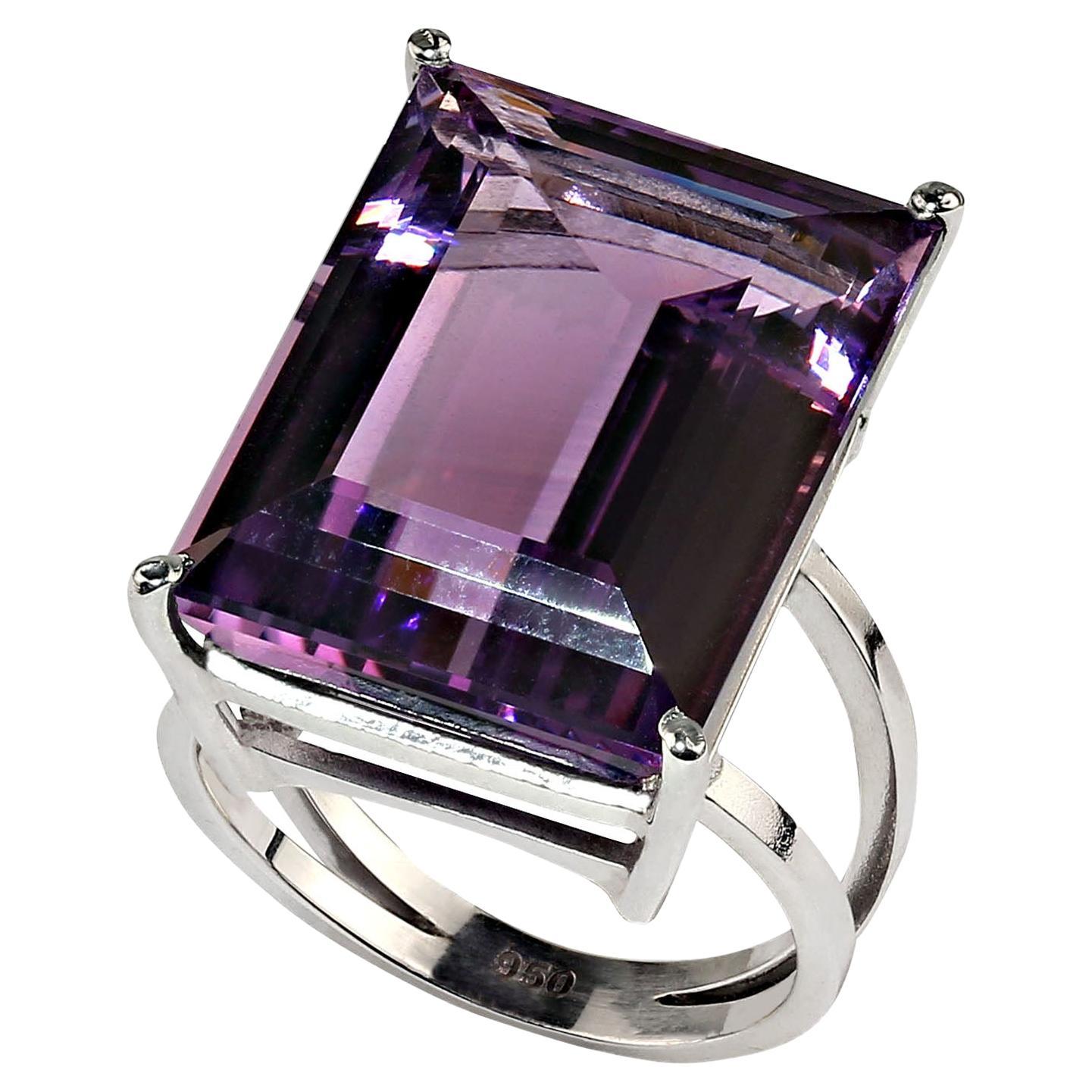 24.3CT Emerald cut Amethyst set in a handmade Sterling Silver ring.  This elegant ring was created by our favorite vendor is Belo Horizonte, Minas Gerais, Brasil. His craftmen handmade the unique basket style setting to perfectly fit this 20X15MM