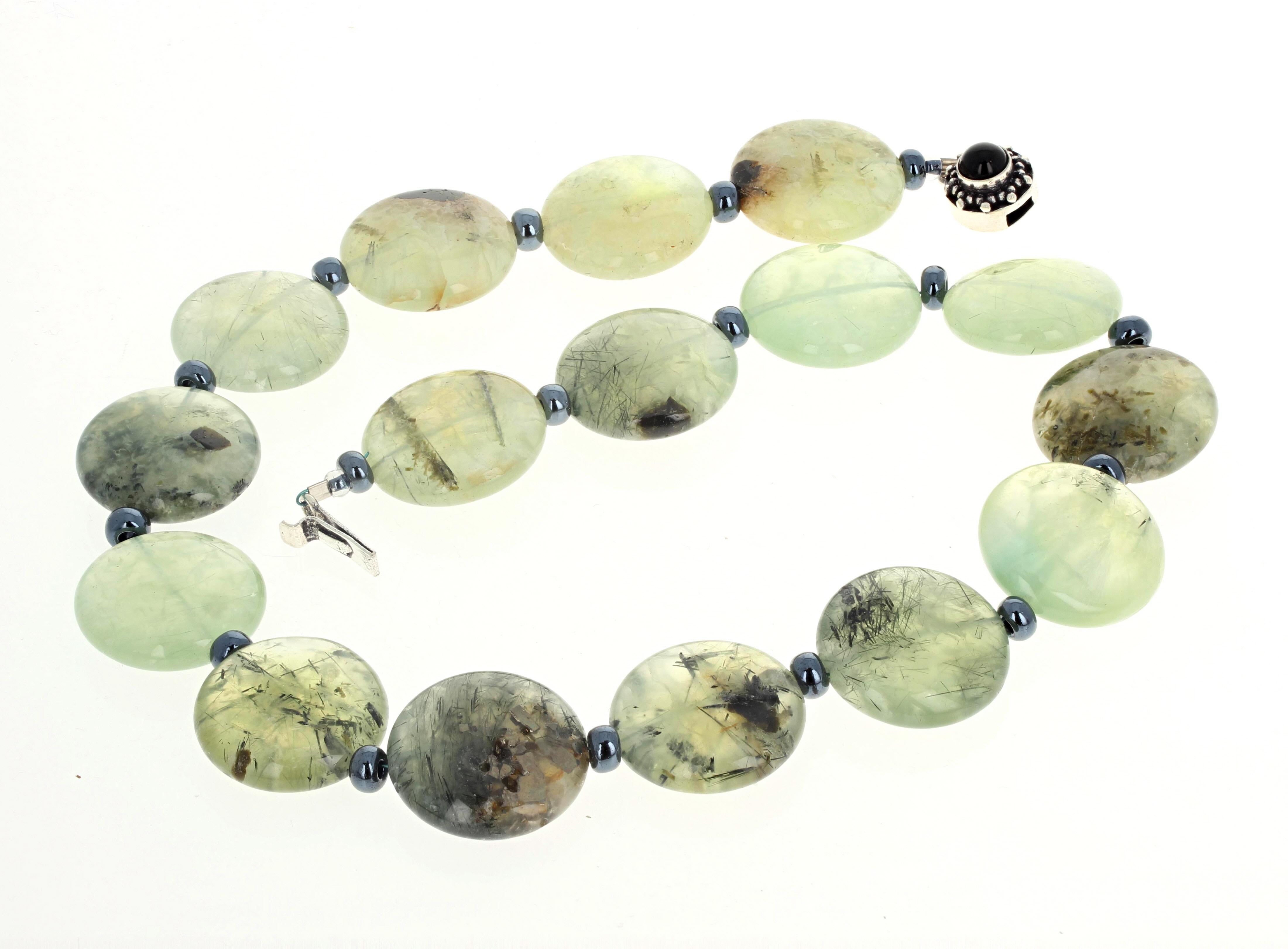 These highly polished natural real Prehnite rondels compose this 19 inch long necklace.  The Prehnites are approximately 25mm and are enhanced by little brightly glowing dark greyish rondels.  The clasp is an easy to us slide-in silver clasp.