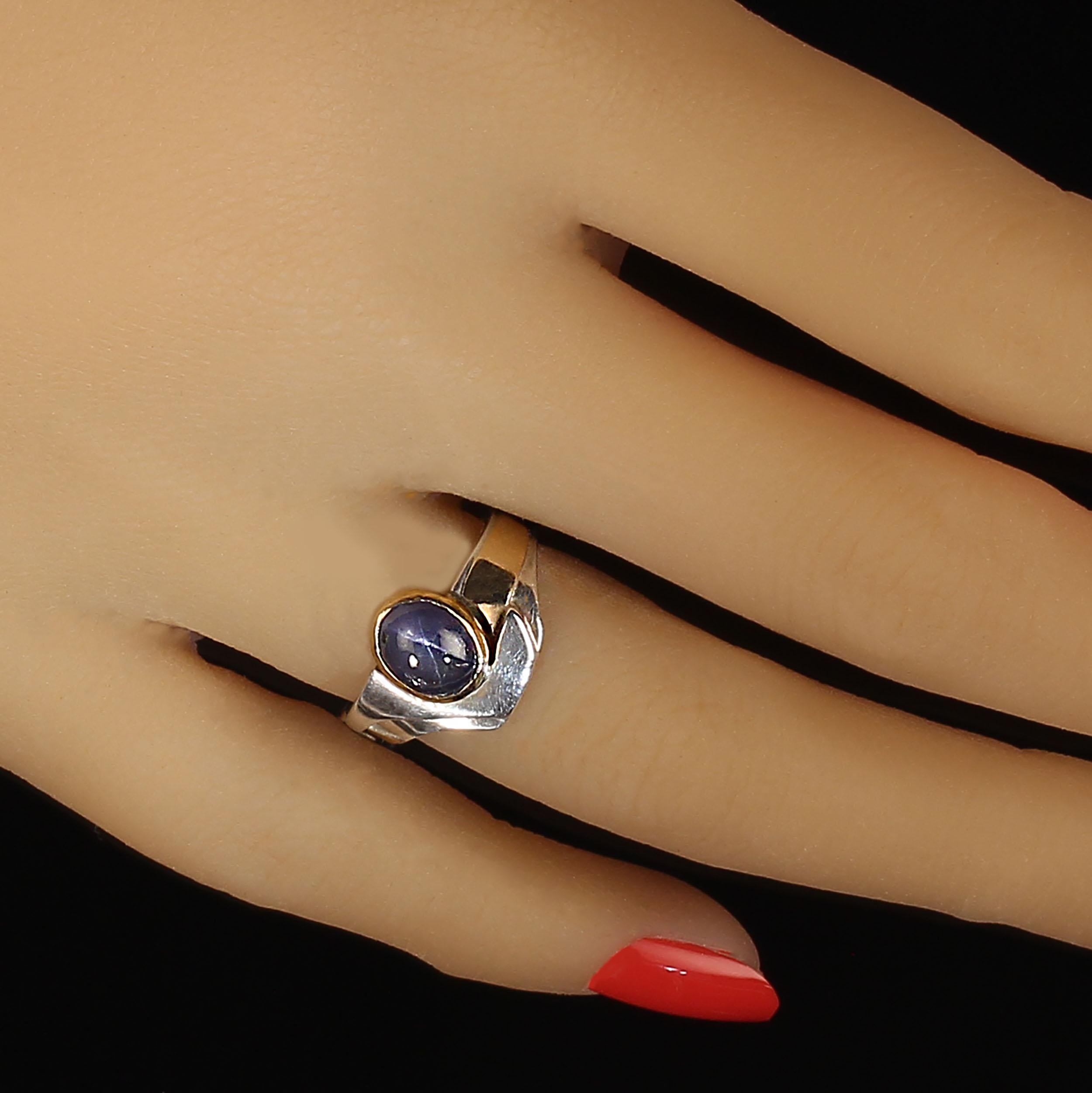 One of a kind blue star sapphire set in 18K gold bezel with 18K trim on sterling silver band.  This unique handmade ring was created in Brazil. The elegant simplicity of this ring is something you will want to add to your collection. Sizable 4.5 by
