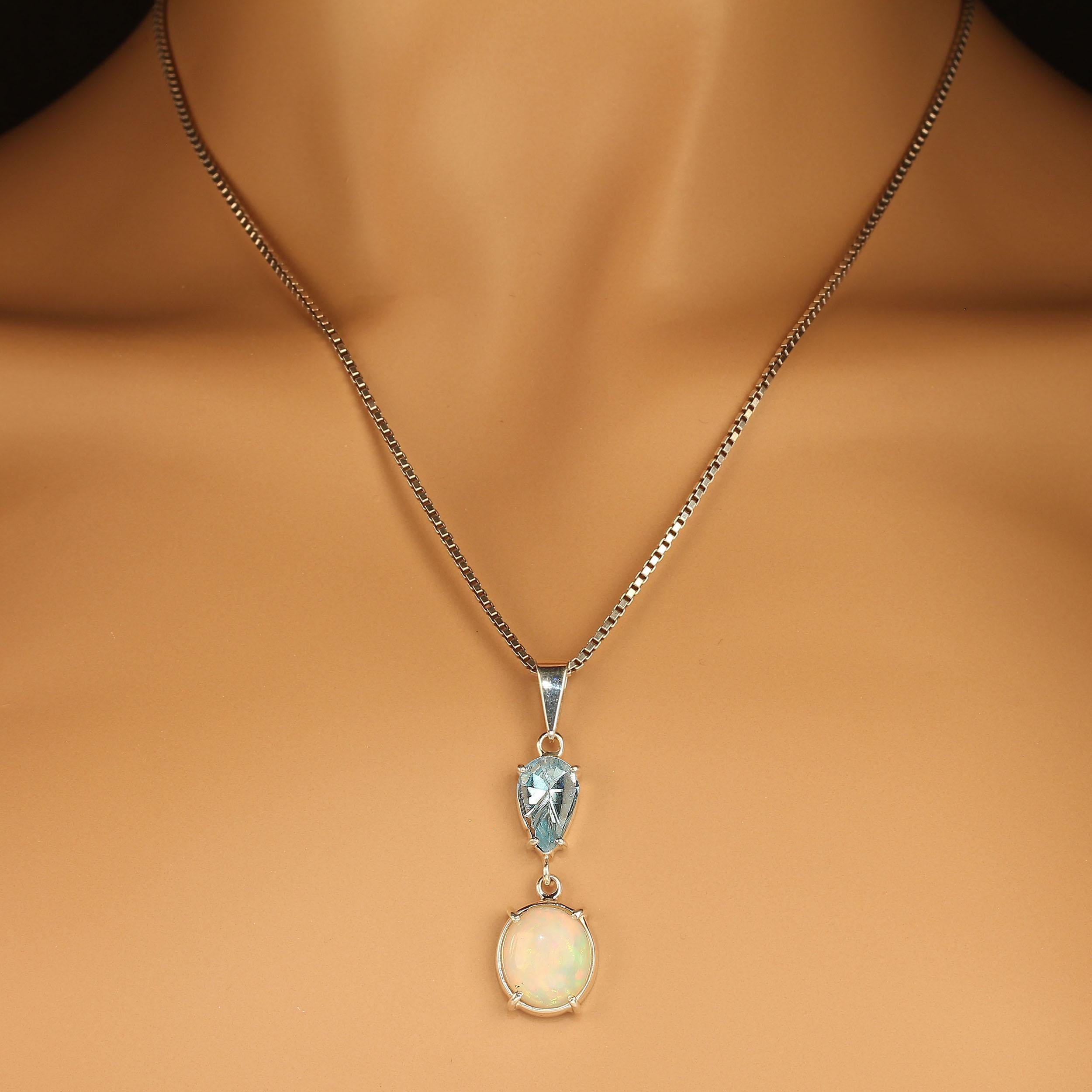 Elegant and unique, this Opal and Blue Topaz pendant is a true beauty.  The 2.35 carat pear shape Blue Topaz lazar cut.  The 3.75 carat roval Opal features terrific flashes of red and green. The pendant is handmade in sterling silver. 
The name Opal