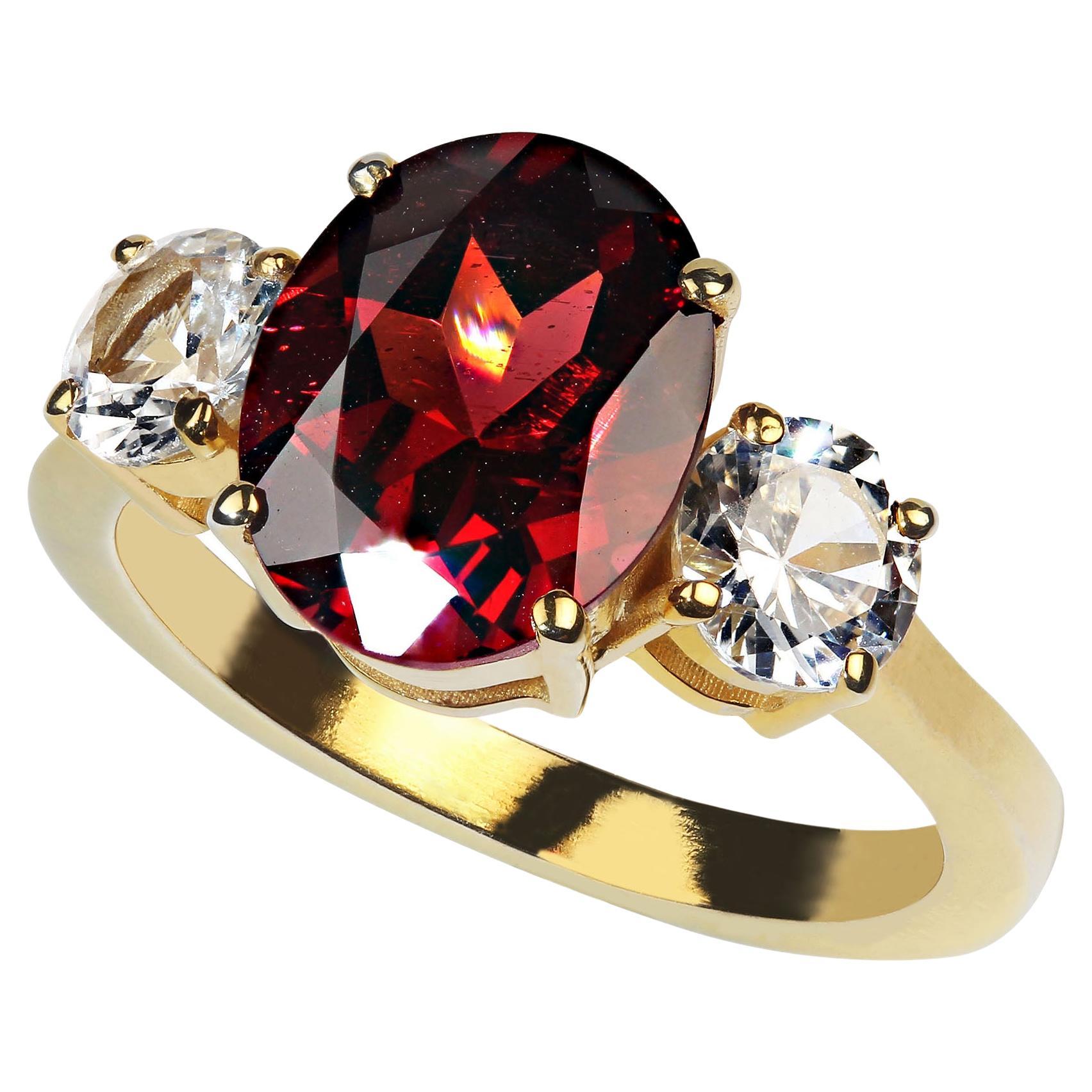 Classic three stone garnet and white sapphire ring. 3.66Ct oval red Garnet and 2 round white sapphires, 1.14cts, in this gorgeous ring.  These genuine gemstones are set in gold rhodium over sterling silver in the classic three stone setting. No