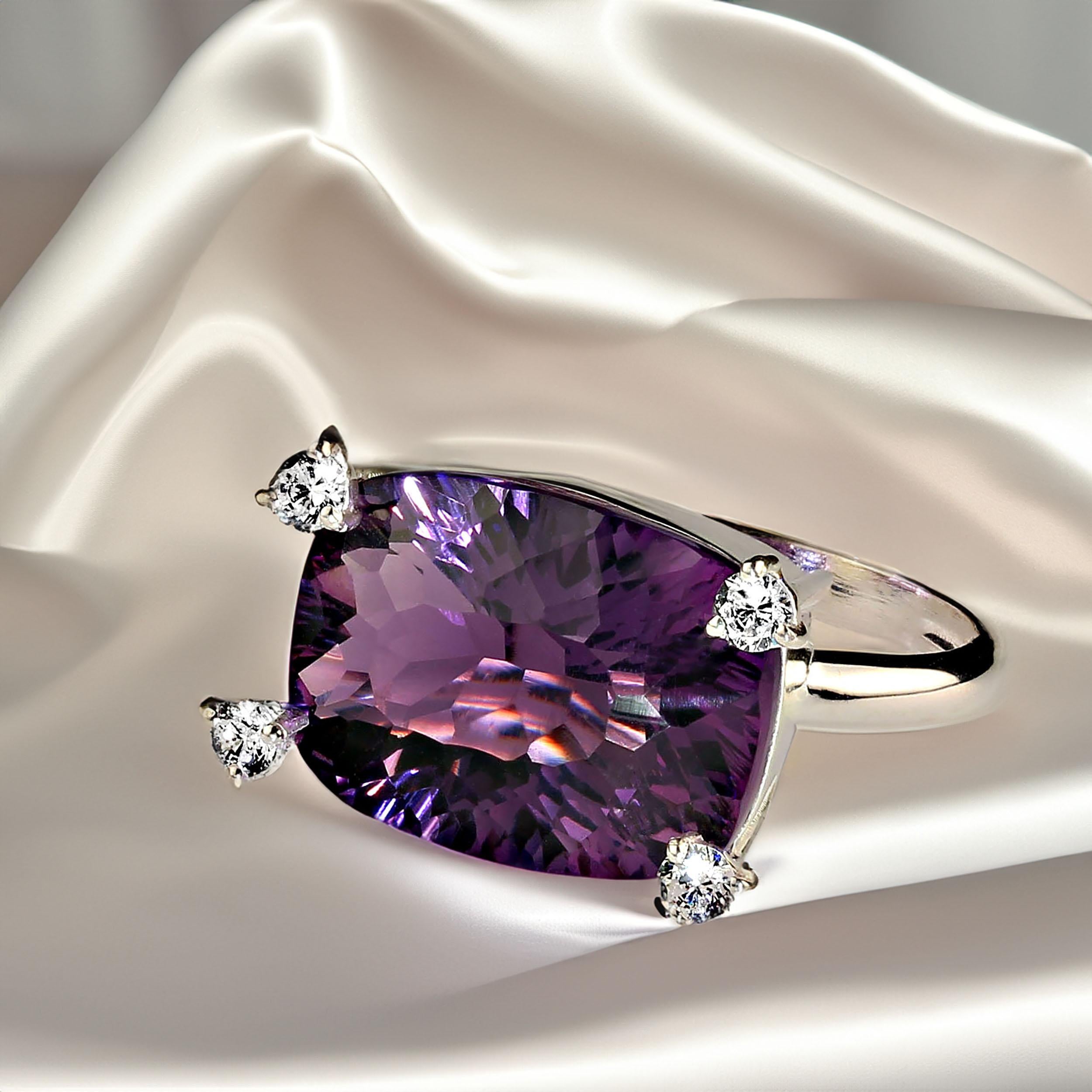 Contemporary ring of special cut Amethyst that has amazing sparkle and four highly set scintallating white zircons.  The zircons cover each corner of the east-west set rectangular amethyst, 13.70ct. The zircons are 0.60ct. The ring is sterling
