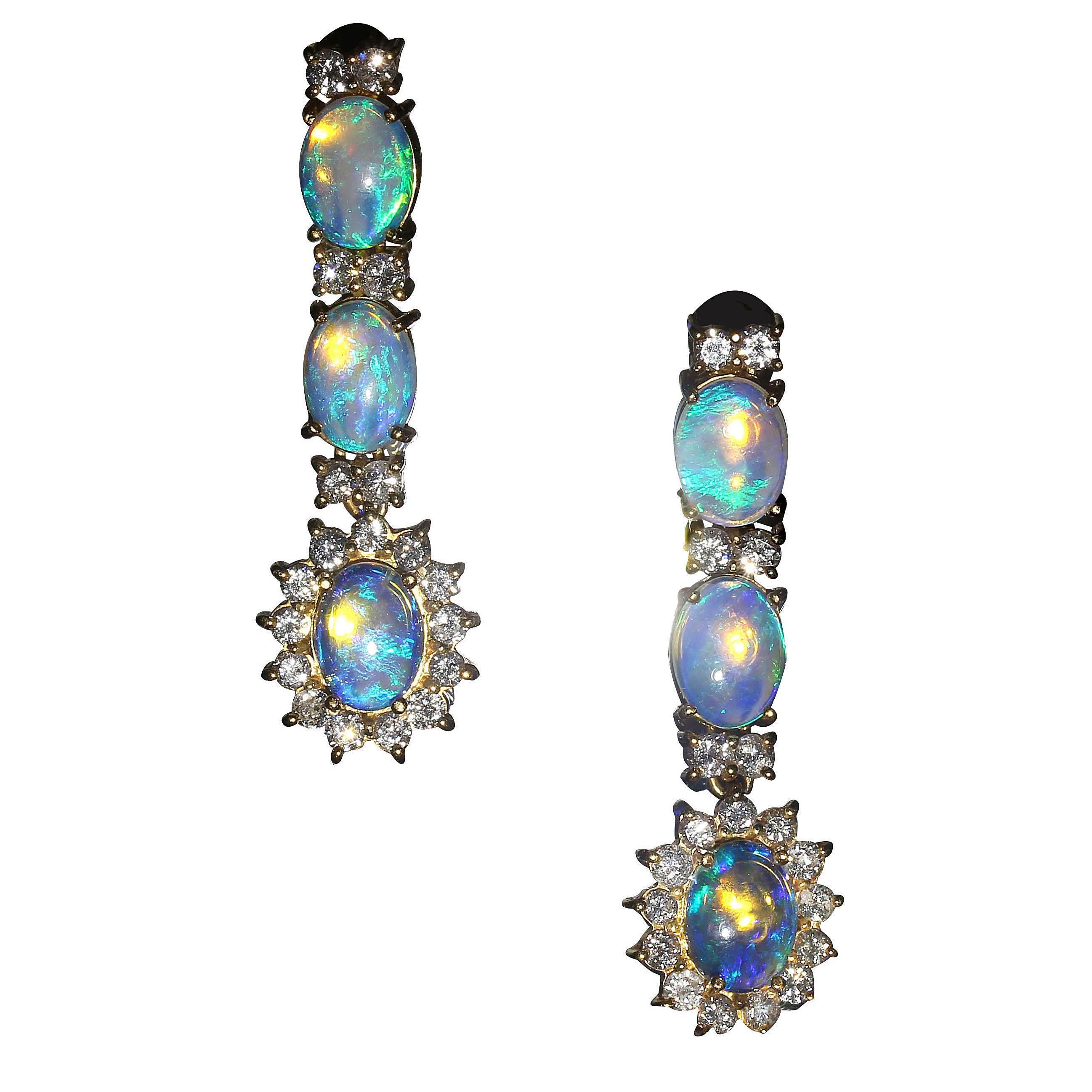 Glow and glitter, Opals and Diamonds. These earrings are a delight to wear. They are hand made 18K yellow gold.  At 1.5 inches in length, each of the three opals in each earring is enhanced with diamonds.  The third of the three opals is encircled