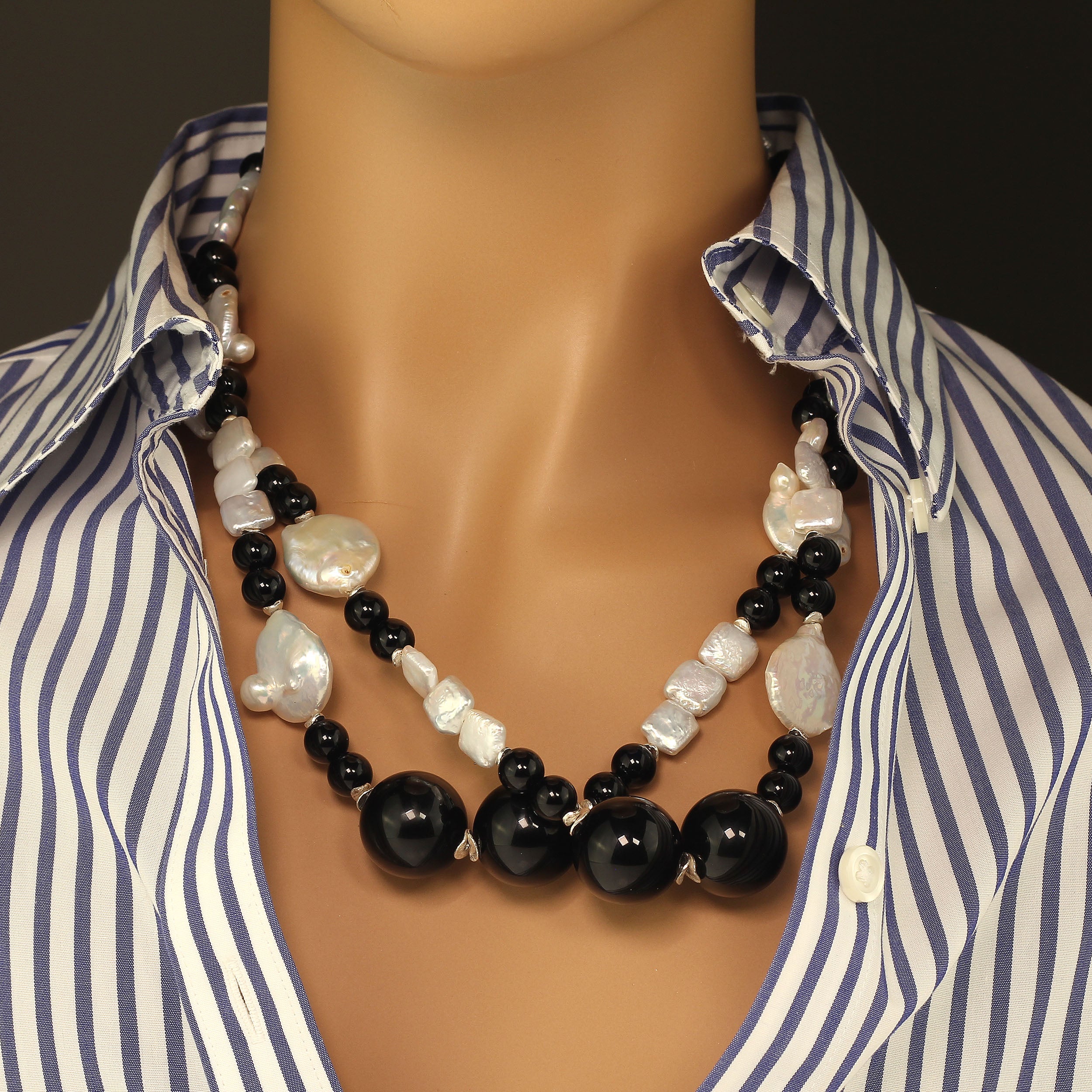 Entdecken Sie die Schönheit dieser atemberaubenden langen Kette aus weißen Münzperlen und schwarzem Onyx, ein zeitloses Stück, das sowohl Eleganz als auch Vielseitigkeit bietet. Sie können es lang tragen oder für einen Lagenlook verdoppeln. Diese