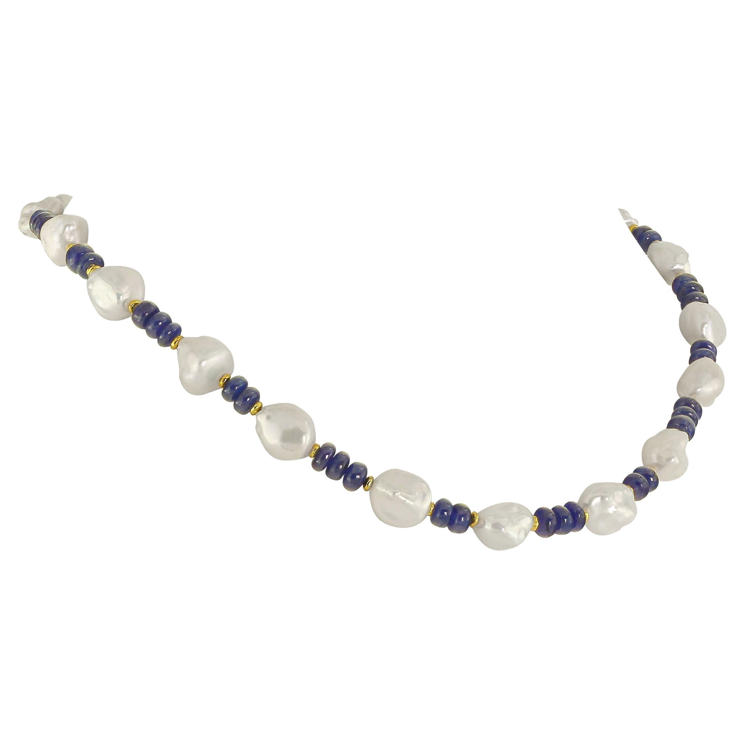 17 inch elegant unique blue Sapphire and white Freshwater Pearl necklace. These are highly polished smoothe rondelles of blue Sapphire (5 MM) with gold tone accents. The lustrous white Chinese Freshwater Pearls (11 MM) are Second Harvest. Together
