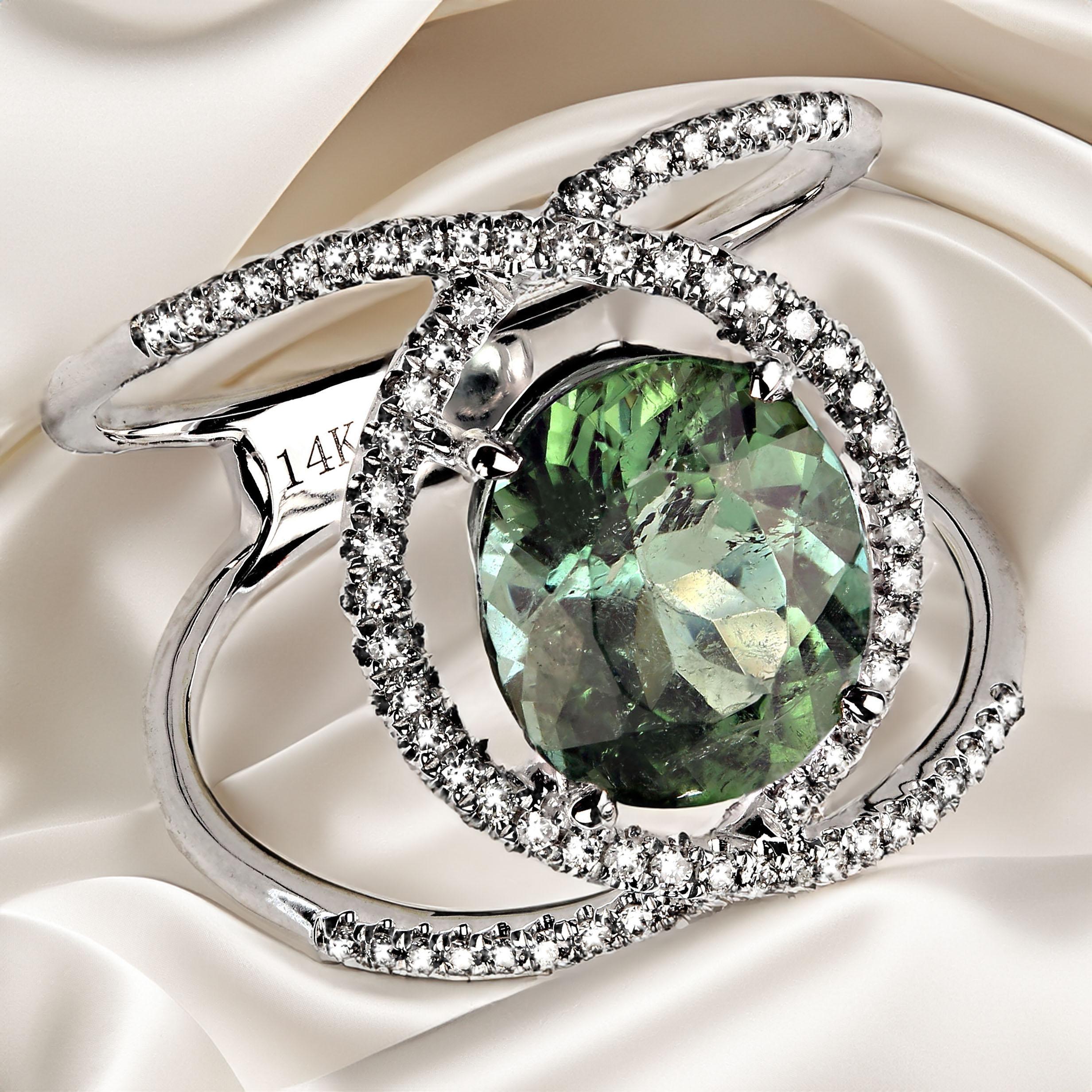 Sparkling oval green tourmaline set in a distinctive modern diamond setting.  This combination enhances both the gorgeous brazilian green tourmaline and the lines of the 14K white gold and diamond setting.  This apple green tourmaline comes from one