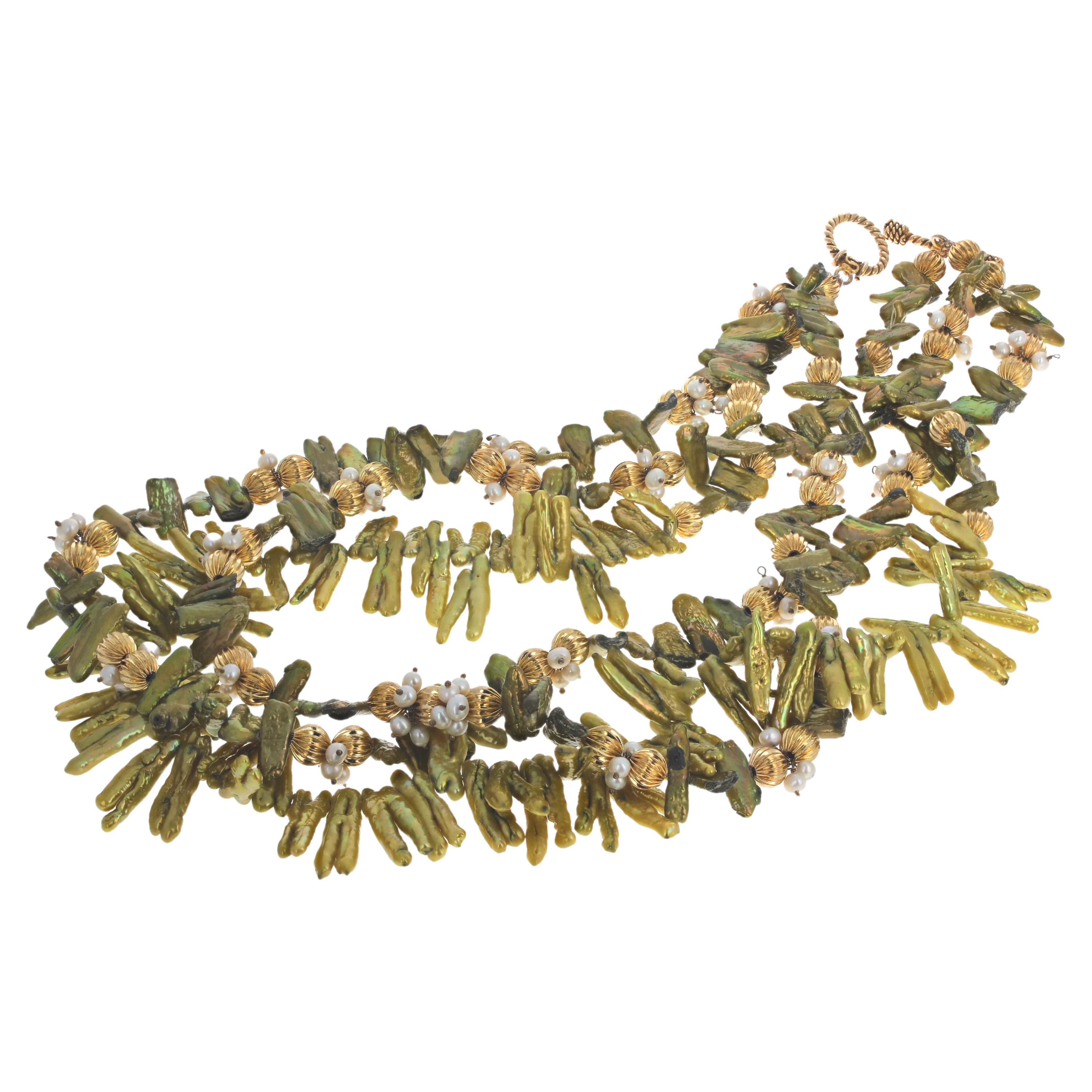 These yellowish/greenish real Pearl Flips are approximately 25mm long x approximately 7mm long.  They glow intensely and are enhanced with round gold plated rondels and little white Pearls. This is a triple strand and the longest one is