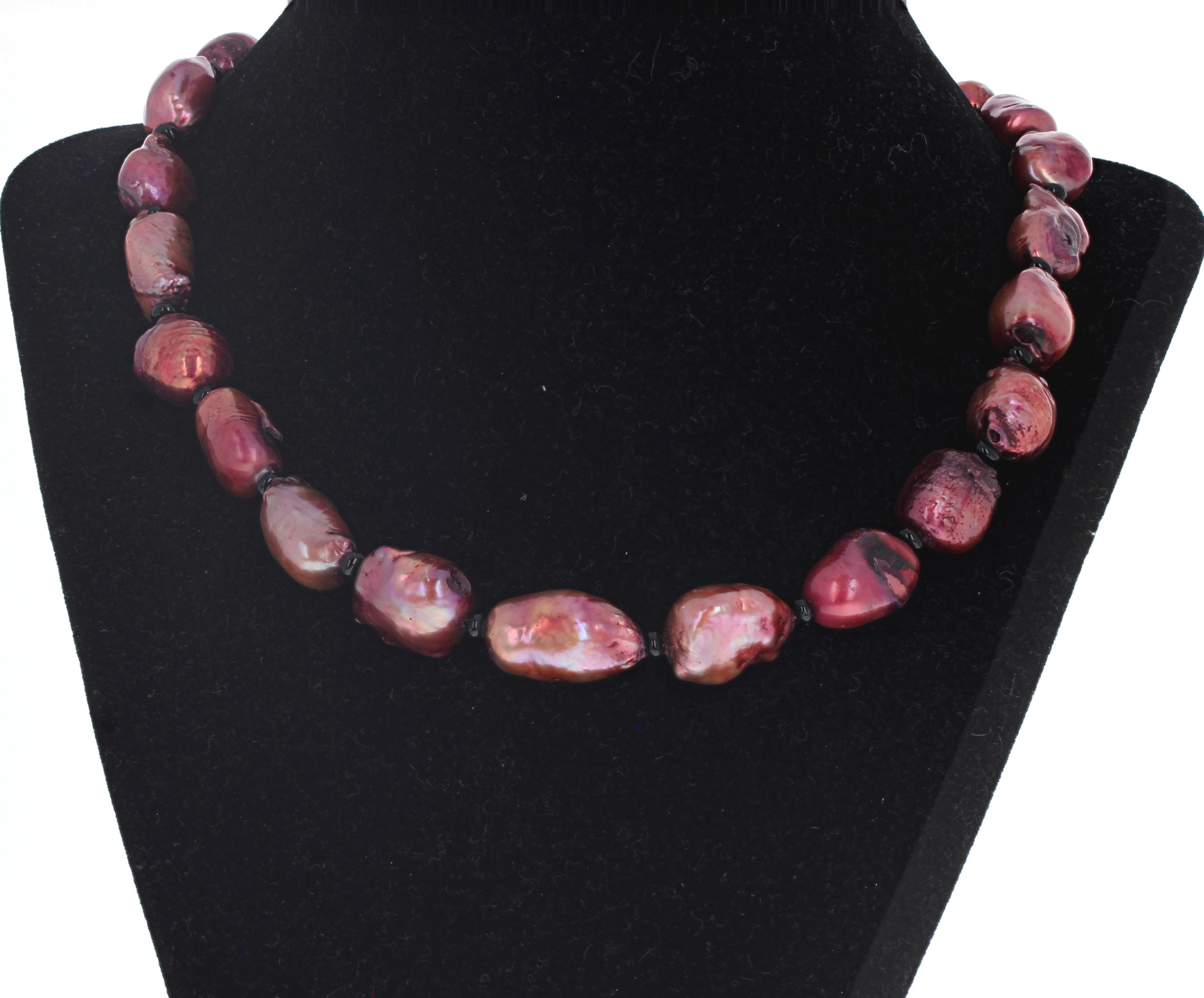 This simple fascinating pinky/coppery cultured Pearl necklace is 17 1/2 inches long.  The largest Pearl is approximately 22mm x 13mm and they are all enhanced by little tiny natural black Onyx rondels.  The clasp is an easy to use silver hook clasp.