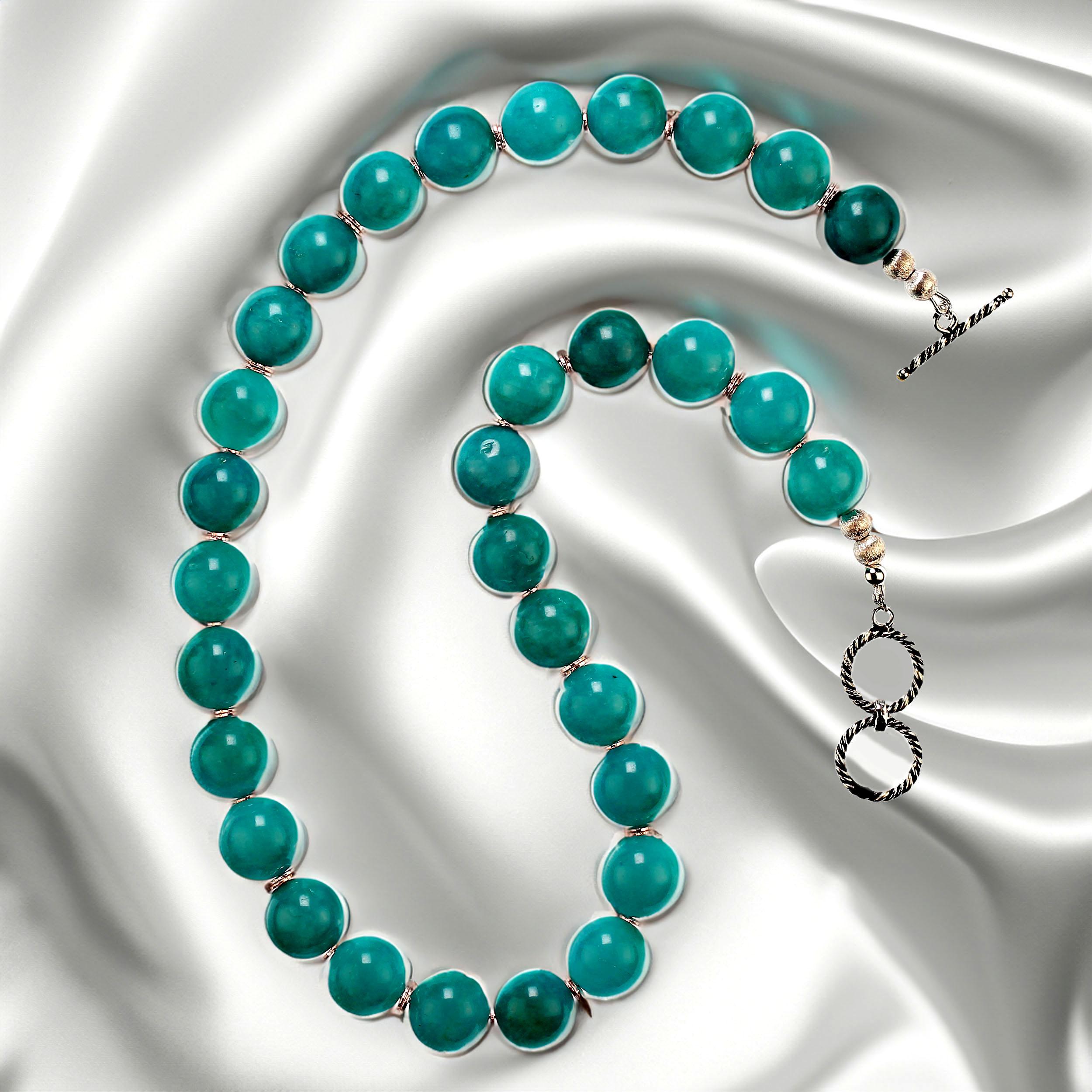 20 Inch necklace of glowing reconstituted amazonite with daisy shape silver tone accents.  This warm, glowing green with a touch of blue necklace is just the perfect finish for all your winter wardrobe.  It is secured with a twisted rope double loop