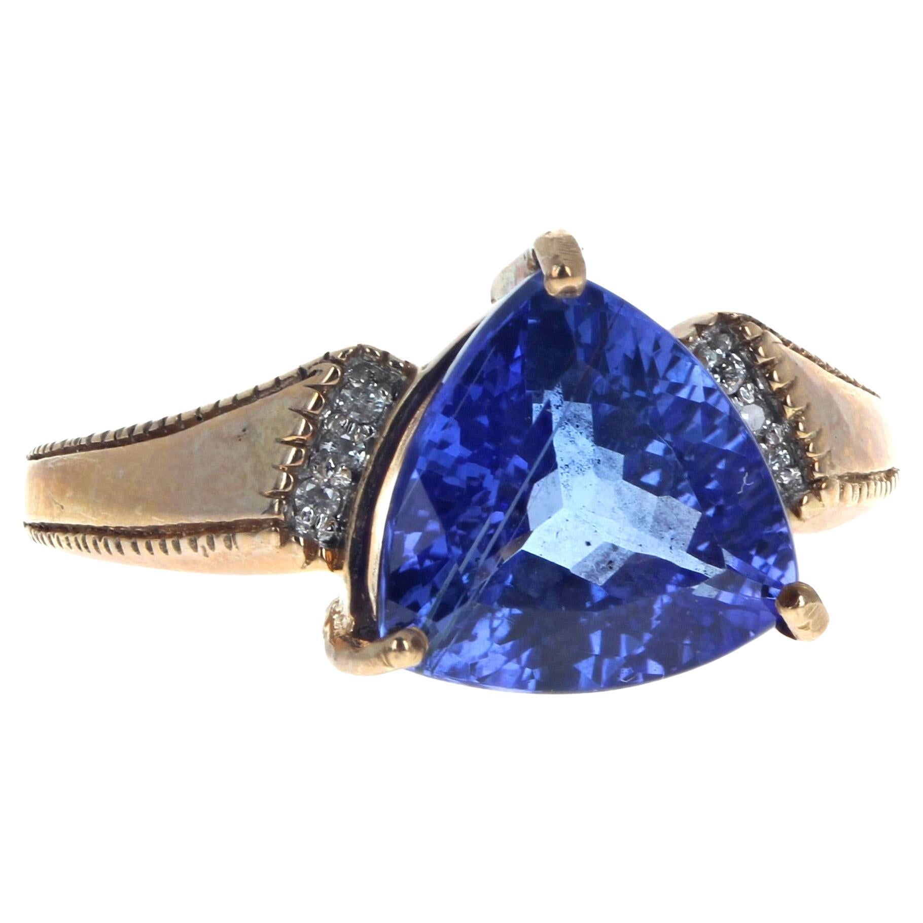 This beautiful ring is 14Kt Yellow Gold size 7.  The center blue Tanzanite gemstone is 2.6 carats and is enhanced on each side by 3 tiny little white Diamonds on each side.  This stands out beautifully on your hand.  