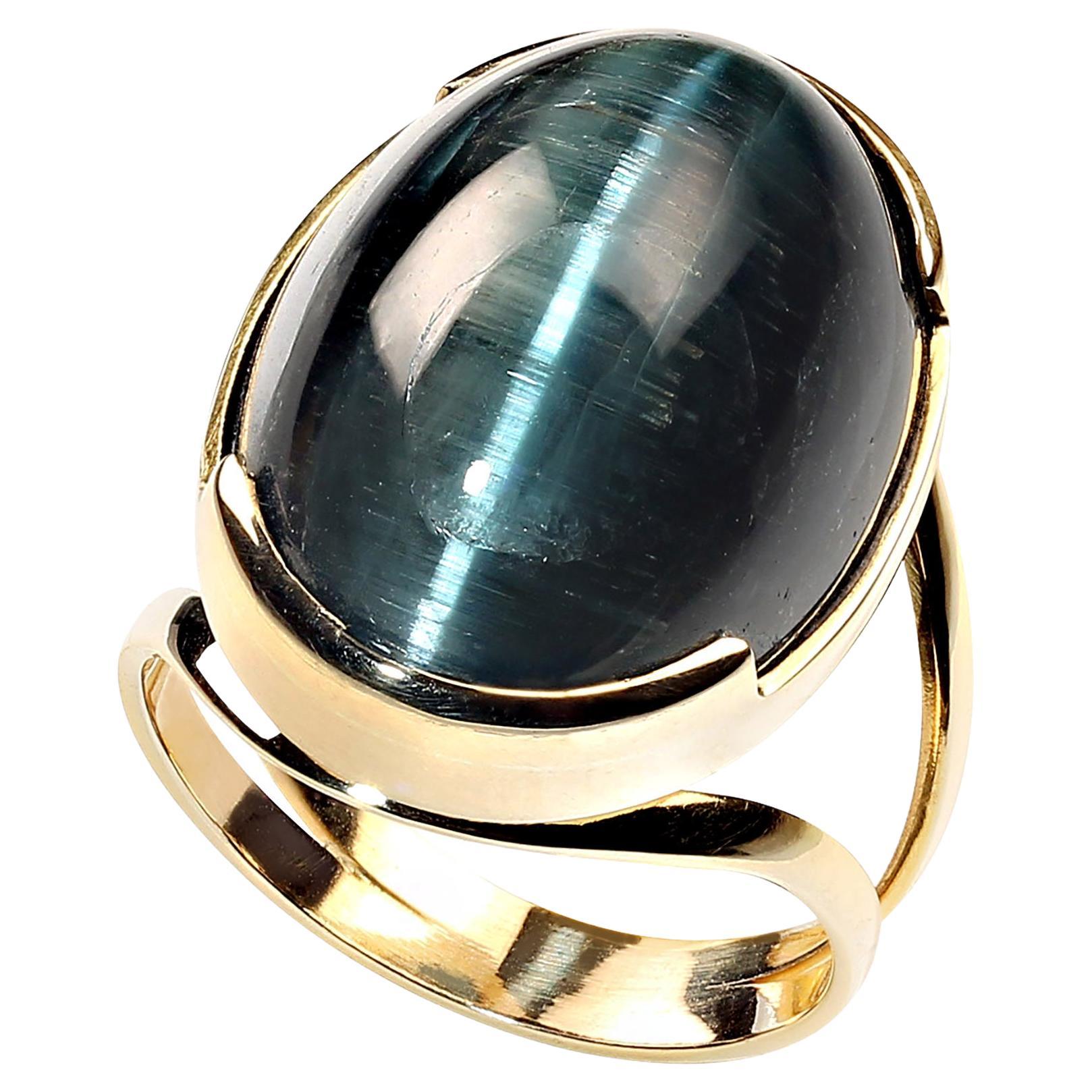 Magnificent 24 carat cat's eye blue-green tourmaline in handmade 18KT gold setting. This unique ring combines the incredible beauty of Brazilian gemstones and quality of Brazilian craftmanship. This oval cabochon is approximately 7/8 inches from