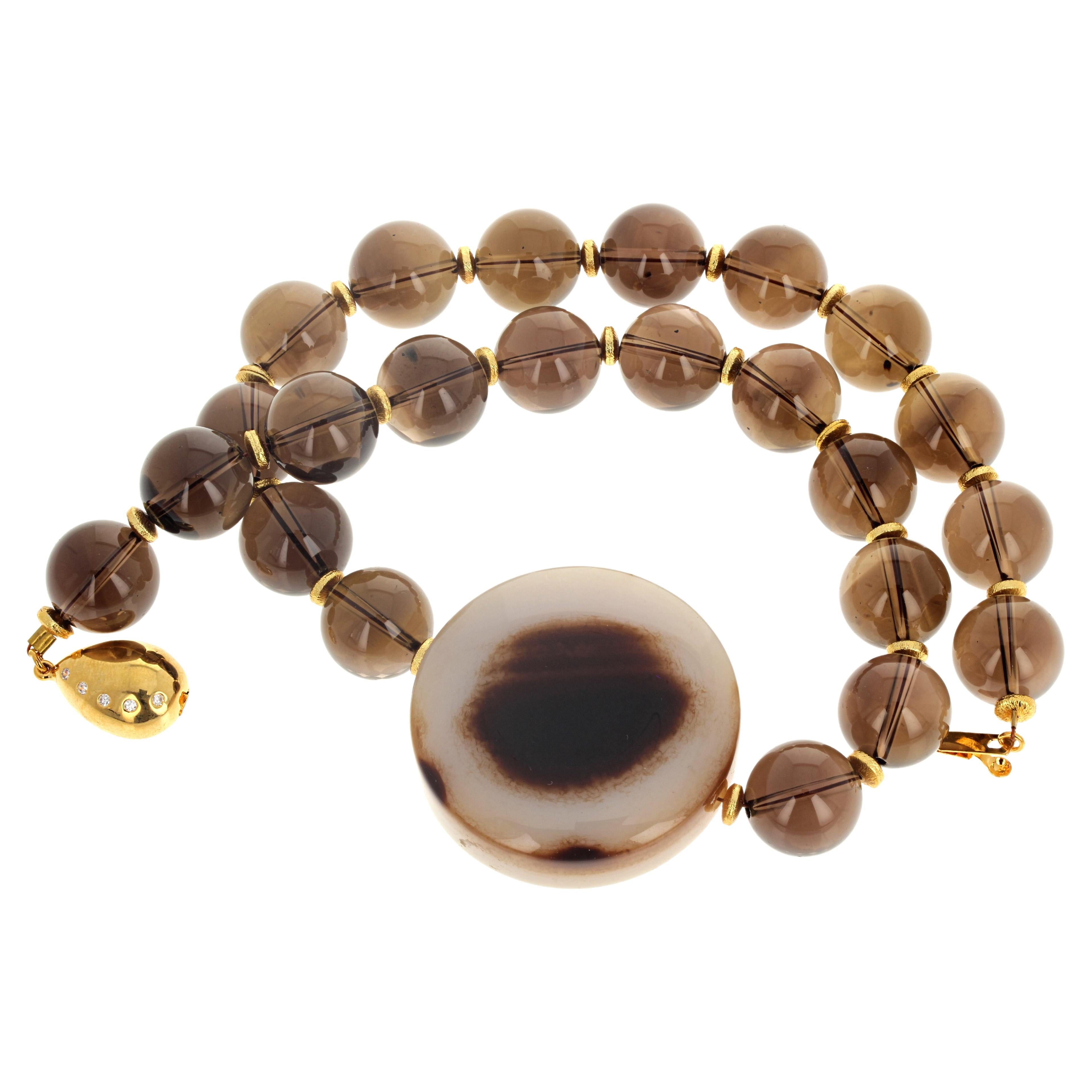  This dramatic natural intense Smoky Quartz (14mm) and beautiful polished natural Agate (40mm) necklace is 17 1/5 inches long enhanced with little gold plated spacers.  The gold plated clasp is an easy to use click in clasp.