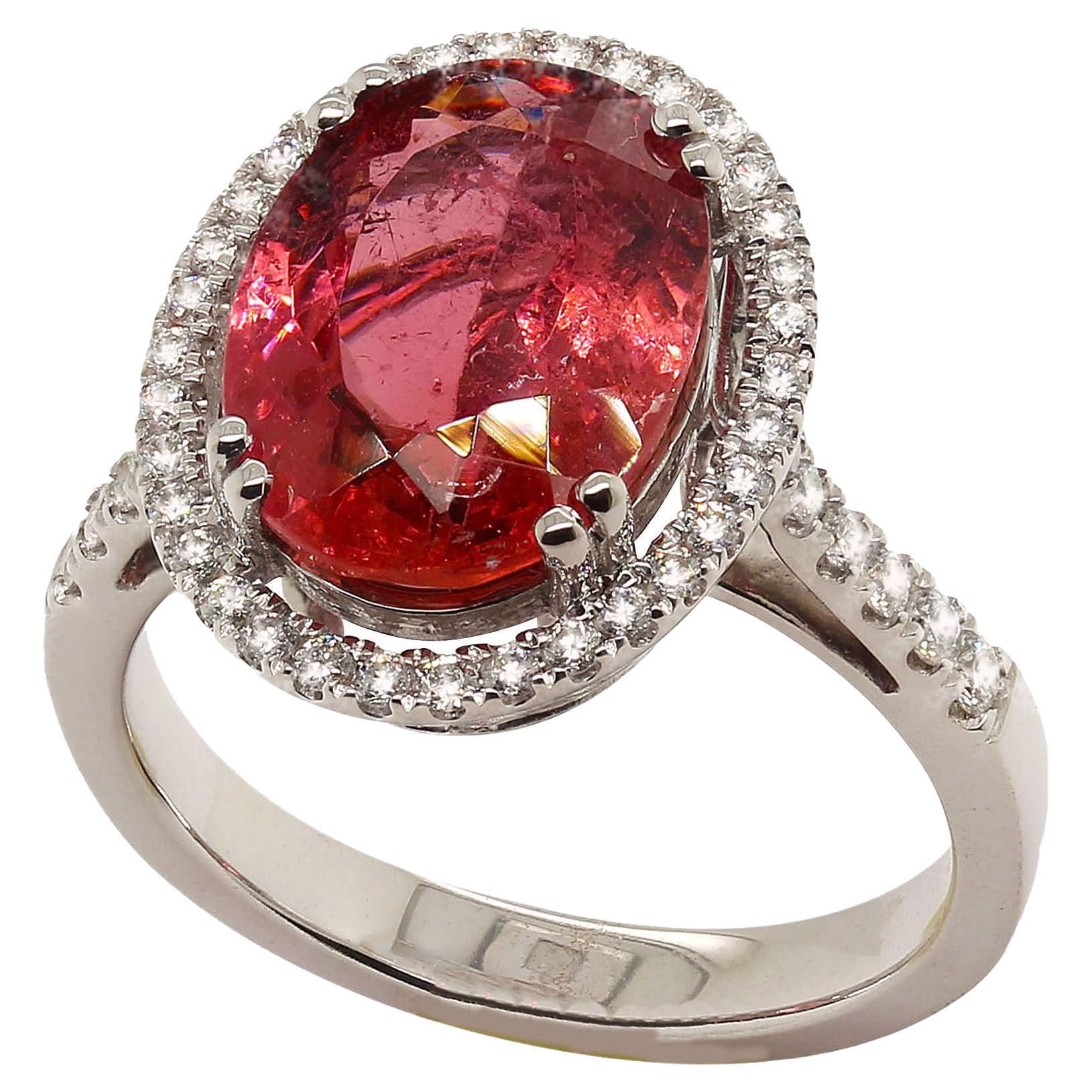 Lovely Dinner ring of Pink Tourmaline halo set with sparkling Diamonds and continue down the shank. Beautiful hand made 14K white gold setting is a sizable 6.75.  See your local jeweler for sizing. The Brazilian Pink Tourmaline comes from one of our