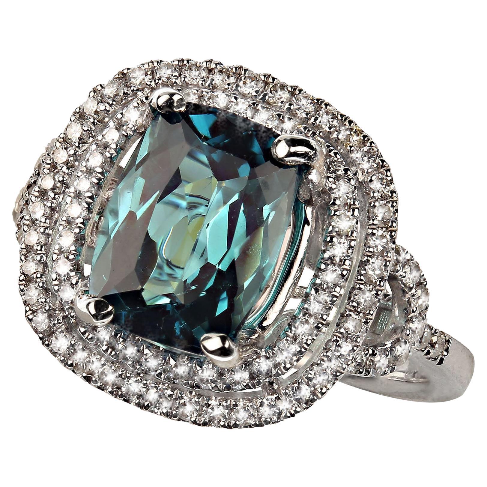 Entdecken Sie die atemberaubende Eleganz dieses blauen Turmalinrings mit einem 2,54-karätigen, antiken Edelstein im Kissenschliff, der durch zwei Reihen funkelnder Diamanten wunderbar ergänzt wird. Dieses exquisite Stück, das direkt von unserem