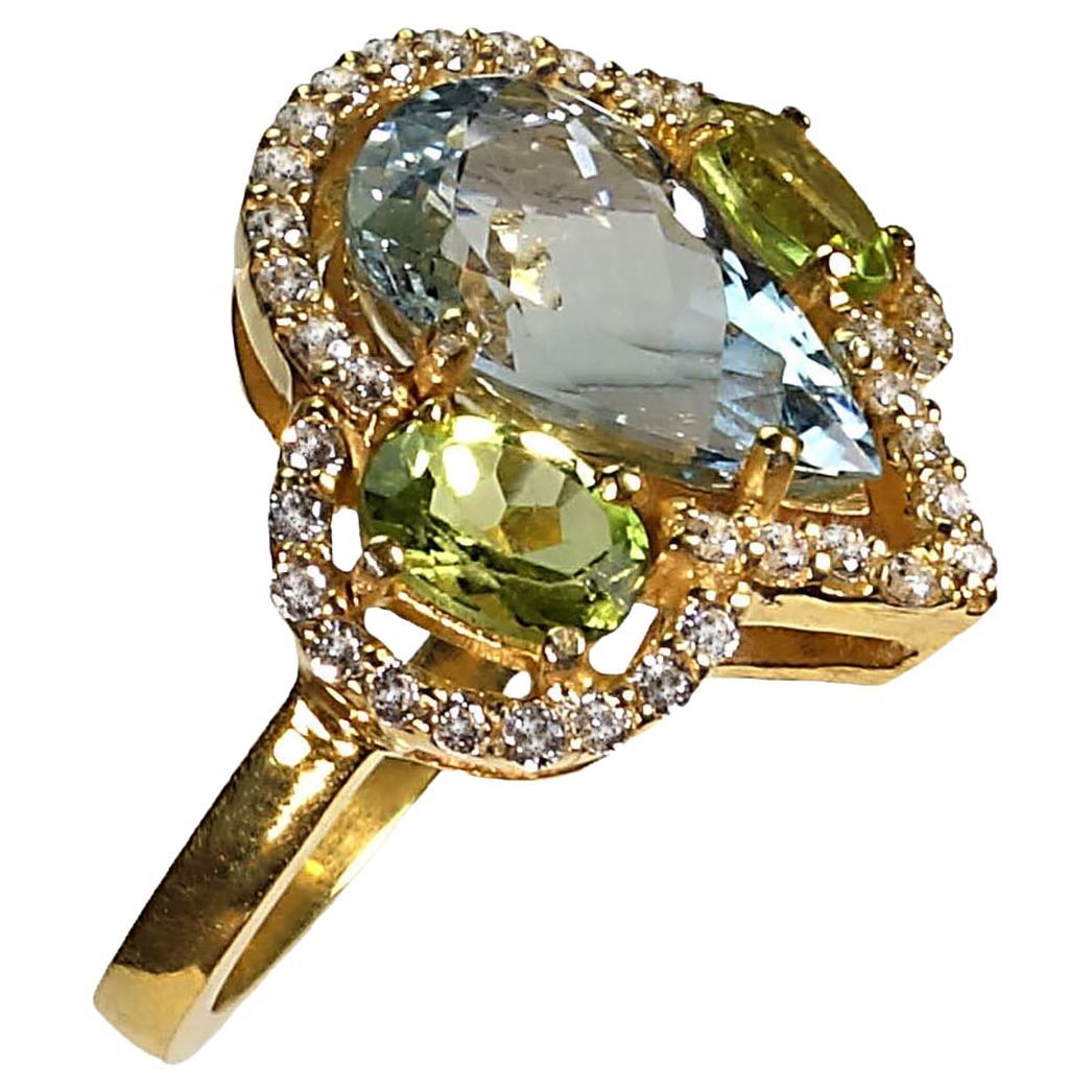Custom made Cocktail ring of sparkling blue pear shaped Aquamarine center stone with oval Peridot side stones. These lovelies are surrounded by glittering genuine Zircons.  Wow!  This isn't just for Cocktails, wear this handmade ring all day every