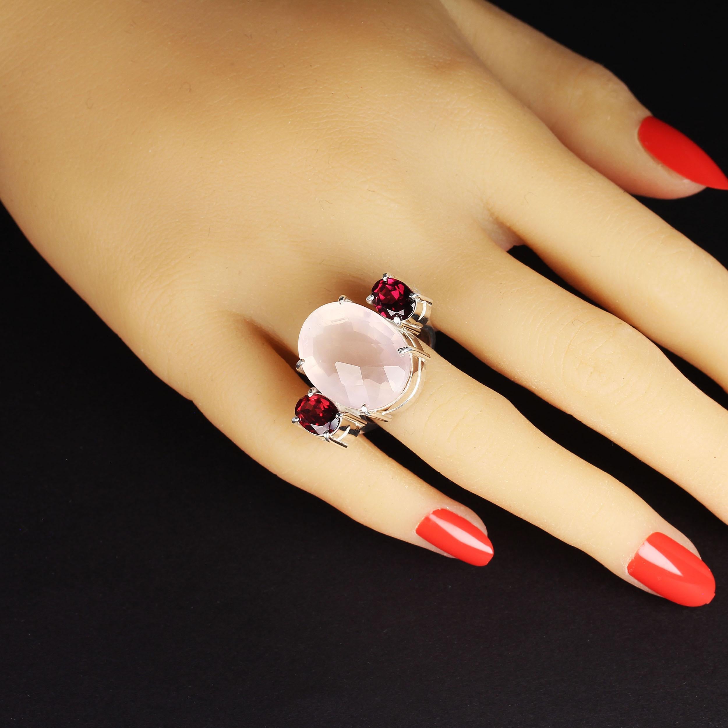 This exciting ring of Rose Quartz and Garnet is just what you want for Valentine's Day and on through the year.  The generous 20.2 carat translucent oval rose quartz features a checkerboard table. The two sparkling oval garnets which accent the rose