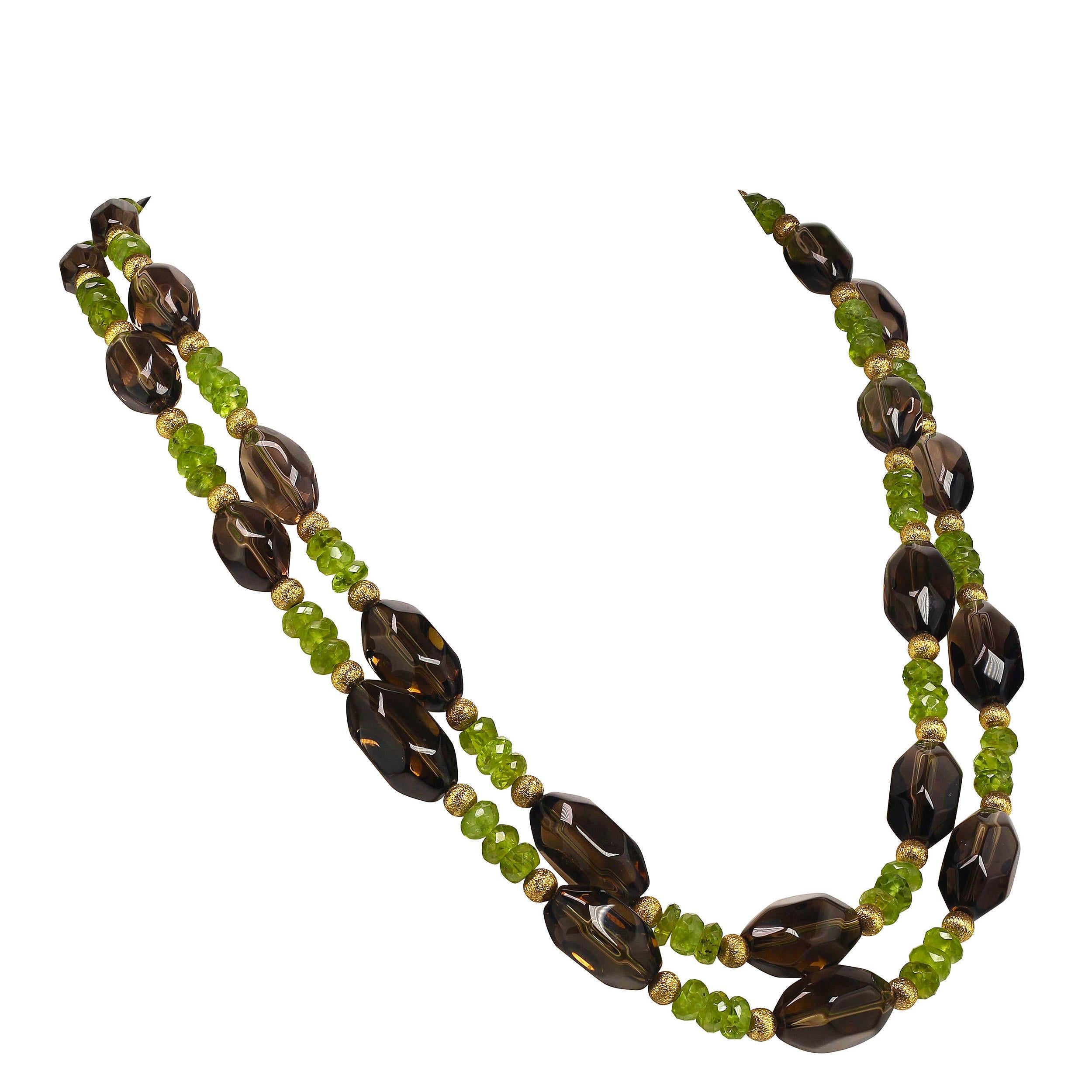 Elegant double strand necklace, 24 and 25 inches, of glowing Smoky Quartz and sparkling Peridot. The Smoky Quartz are three sizes graduating to the largest in front with etched goldy accents. The Peridot are all faceted rondelles. This double strand