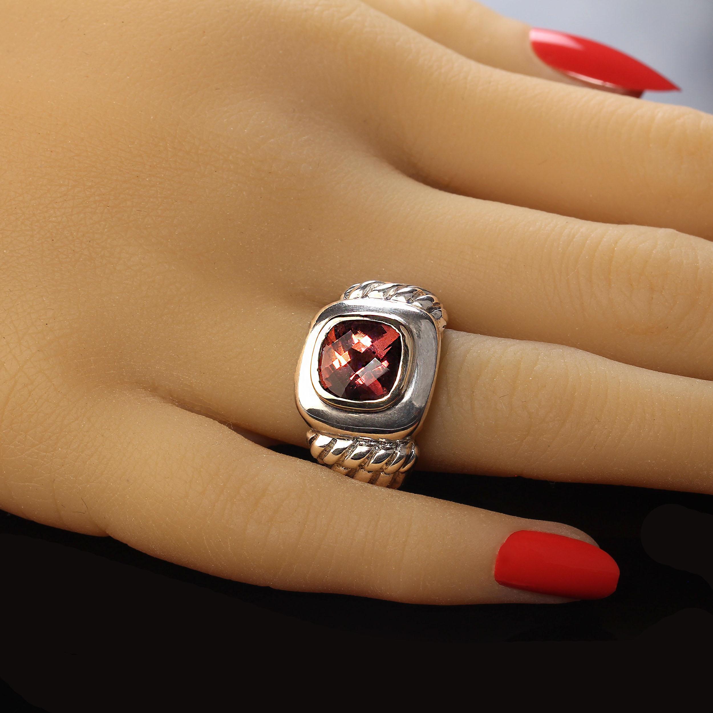 Striking cocktail ring with substantial sterling silver. The cushion cut pinkish red topaz features a checkerboard table and is enhanced with a warm glowing 14K yellow gold bezel. No changes by seller. Size 6. Your local jeweler can size this