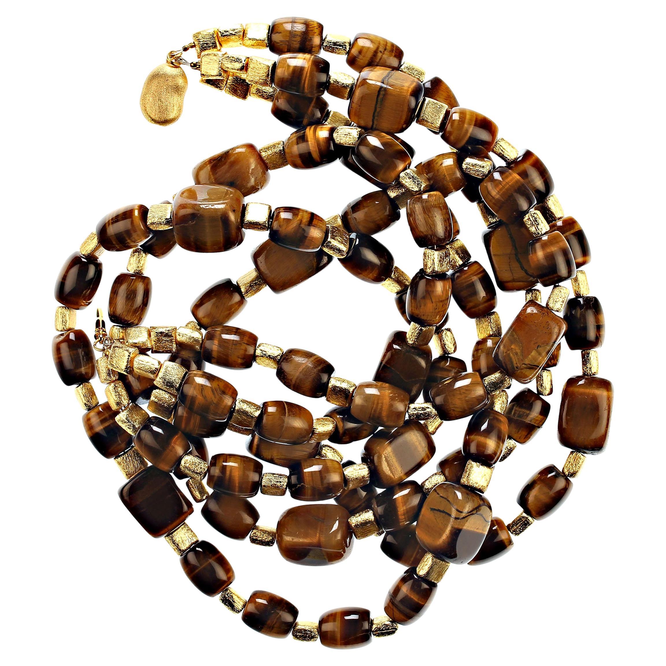 This is a custom made Tiger's Eye Necklace in three strands of eye popping glowing, chatoyant Tiger's Eye. The unusual  barrel and curb shapes with brushed gold tone accents create a unique and pleasing combination of shapes. The necklace is 21