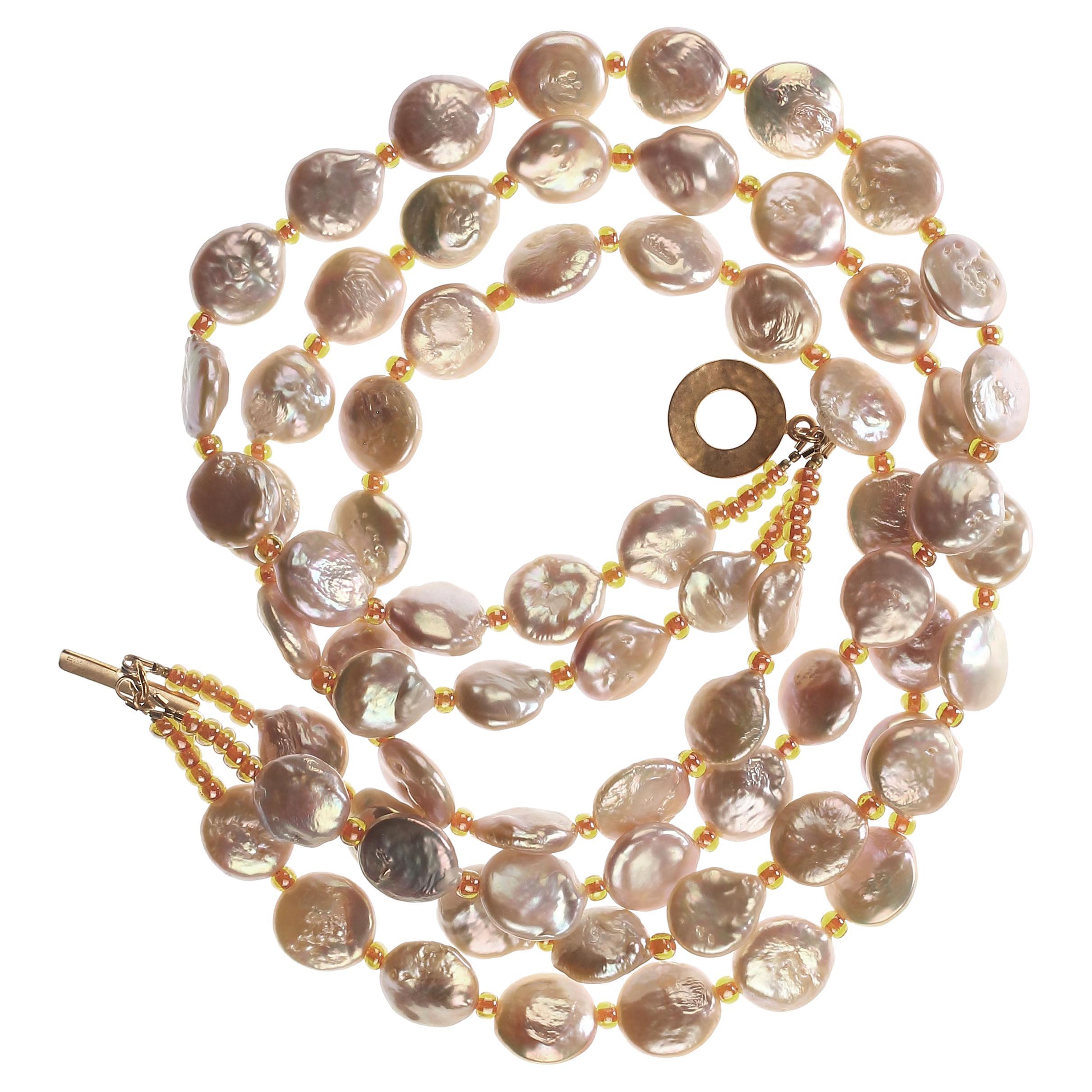 Own the pearls you deserve

Unique Coin Pearl triple strand necklace featuring peachy pink iridescent Coin Pearls and orange Czech beads.   This perfect Spring/Summer necklace is three strands of gorgeous pearls to drape around your neck or gently