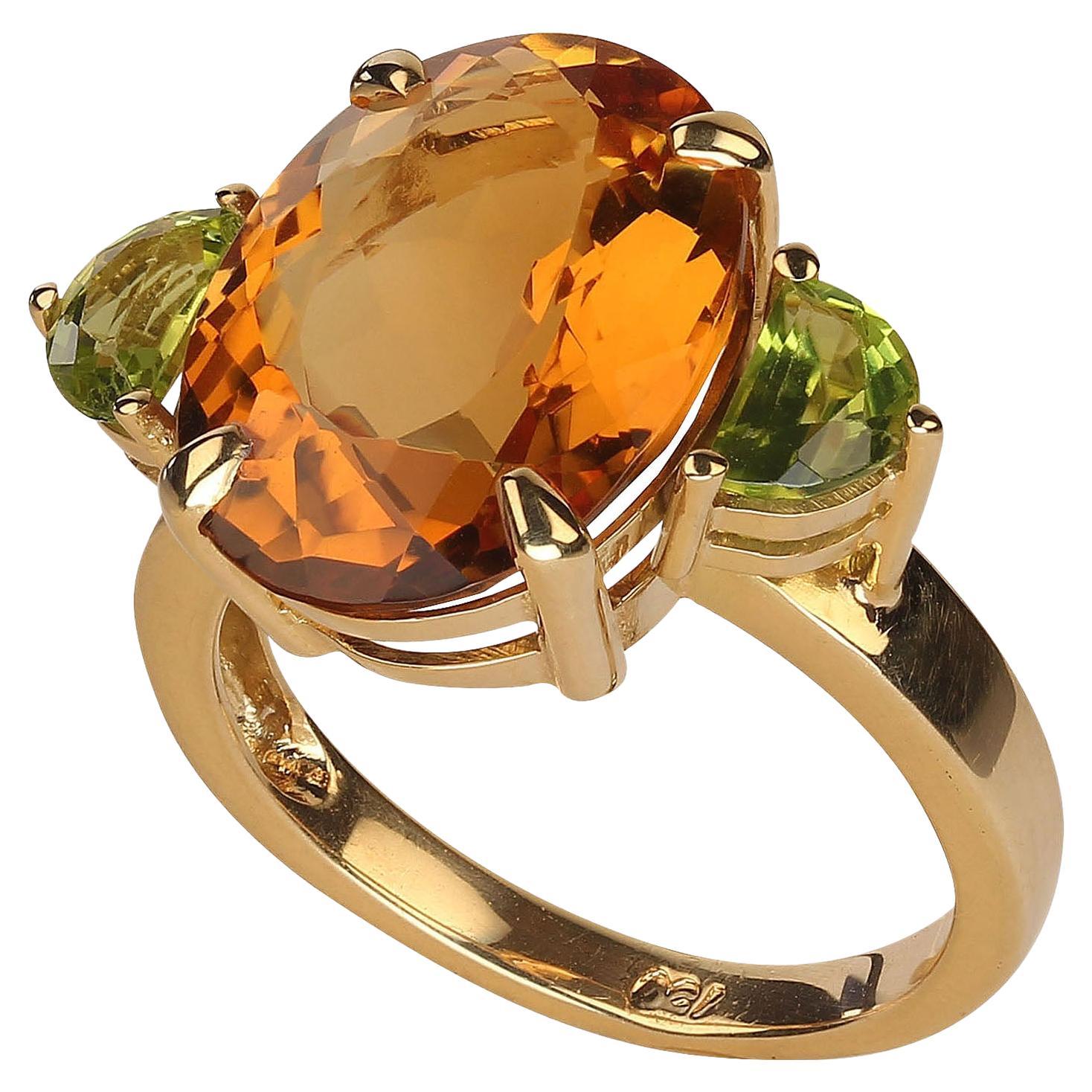 Unique 18K yellow gold ring featuring a gorgeous oval Citrine accented with half moon Peridot on each side.  This one of a kind Brazilian handmade ring is a show stopper.  The 8.54 carat oval Citrine has an aura of golden radiance. Add the sparkling
