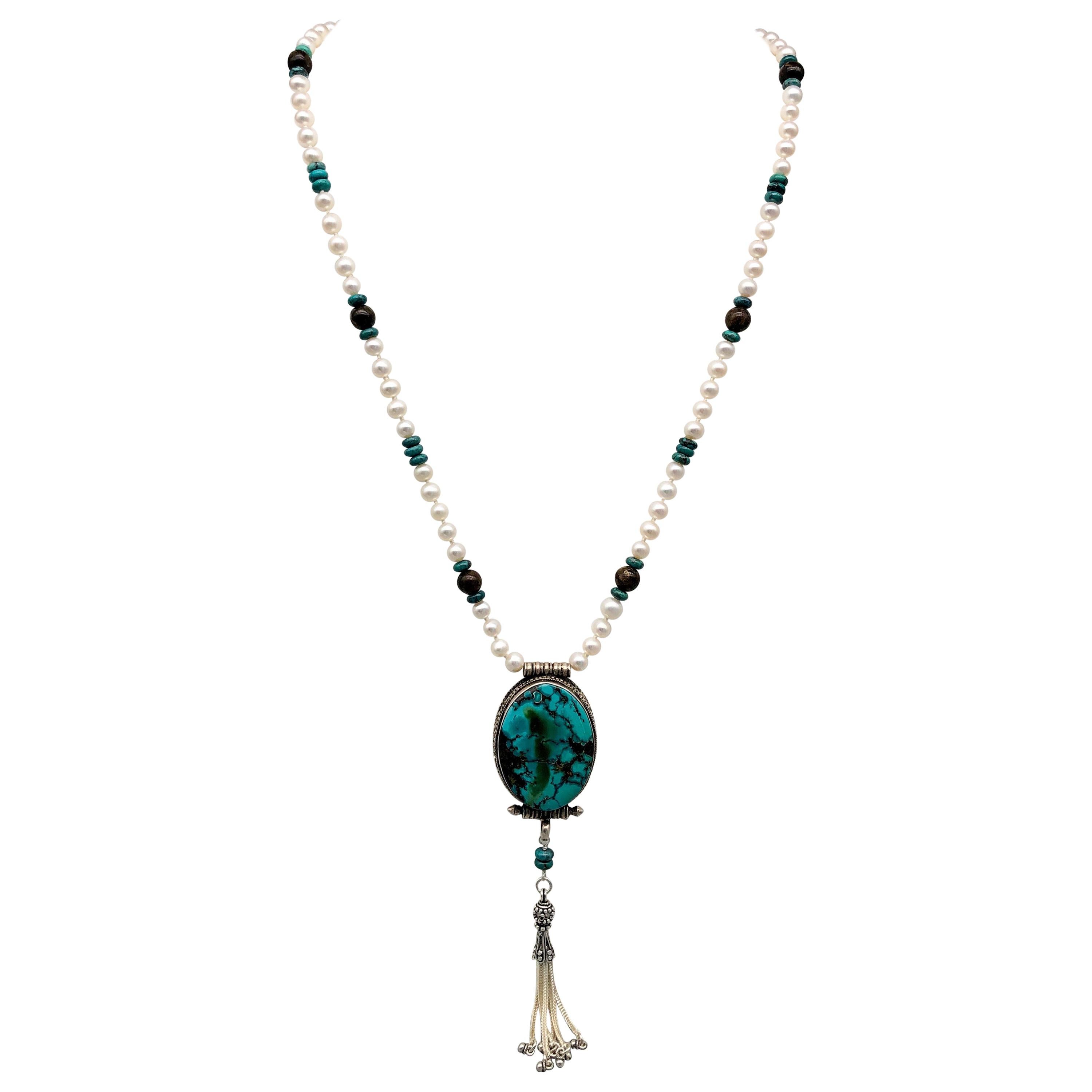 
Introducing the breathtaking One-of-a-Kind Turquoise and Silver Tibetan Pendant Necklace - a true work of art that exudes elegance and sophistication. This long necklace features a stunning piece of Turquoise set in a Silver Tibetian pendant that