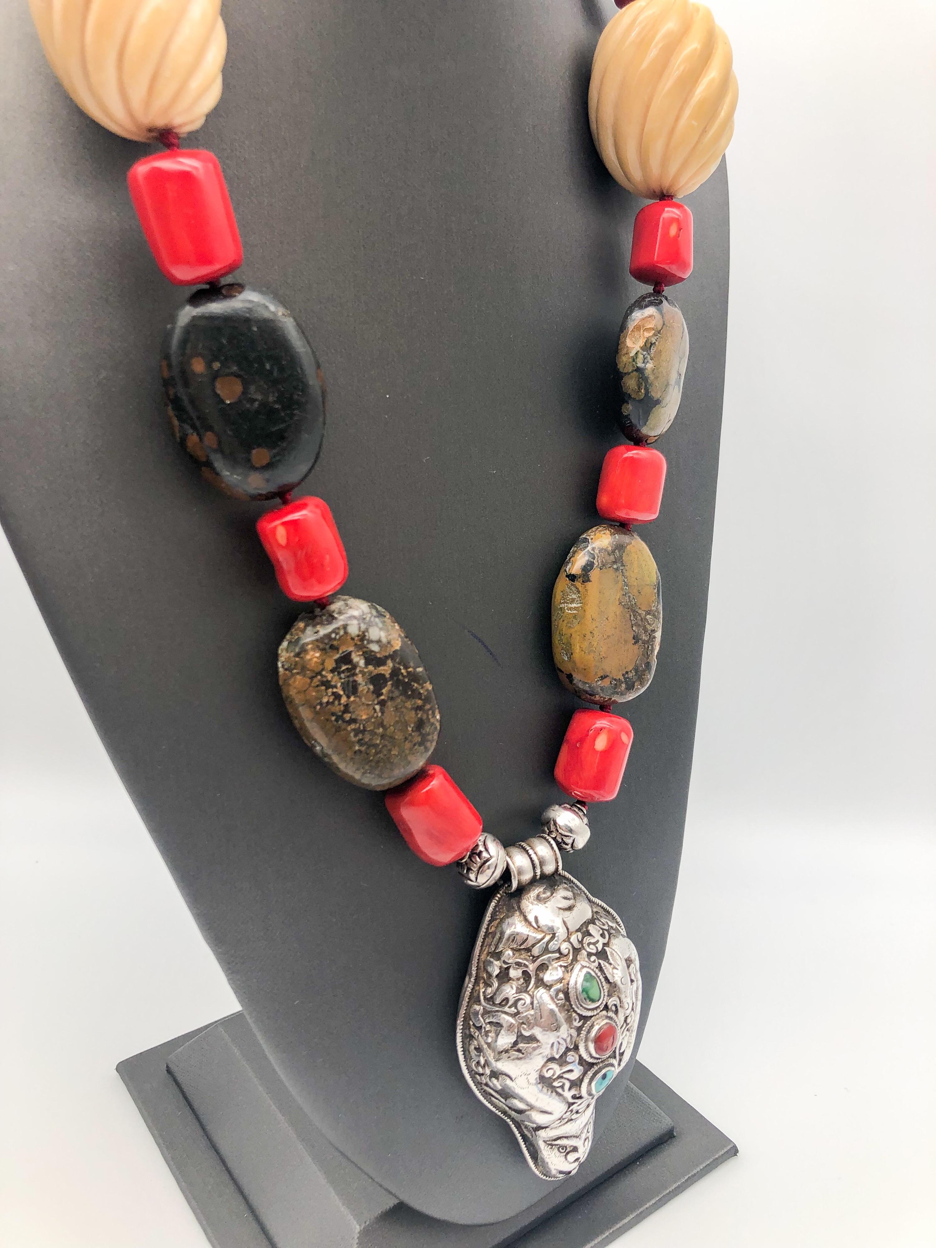 Introducing a stunning one-of-a-kind long necklace that is sure to turn heads and captivate attention. This dramatic piece boasts large brown turquoise plates, carved ox bone beads, Boulder opal, red Chinese lacquered bone, and heavy sterling silver
