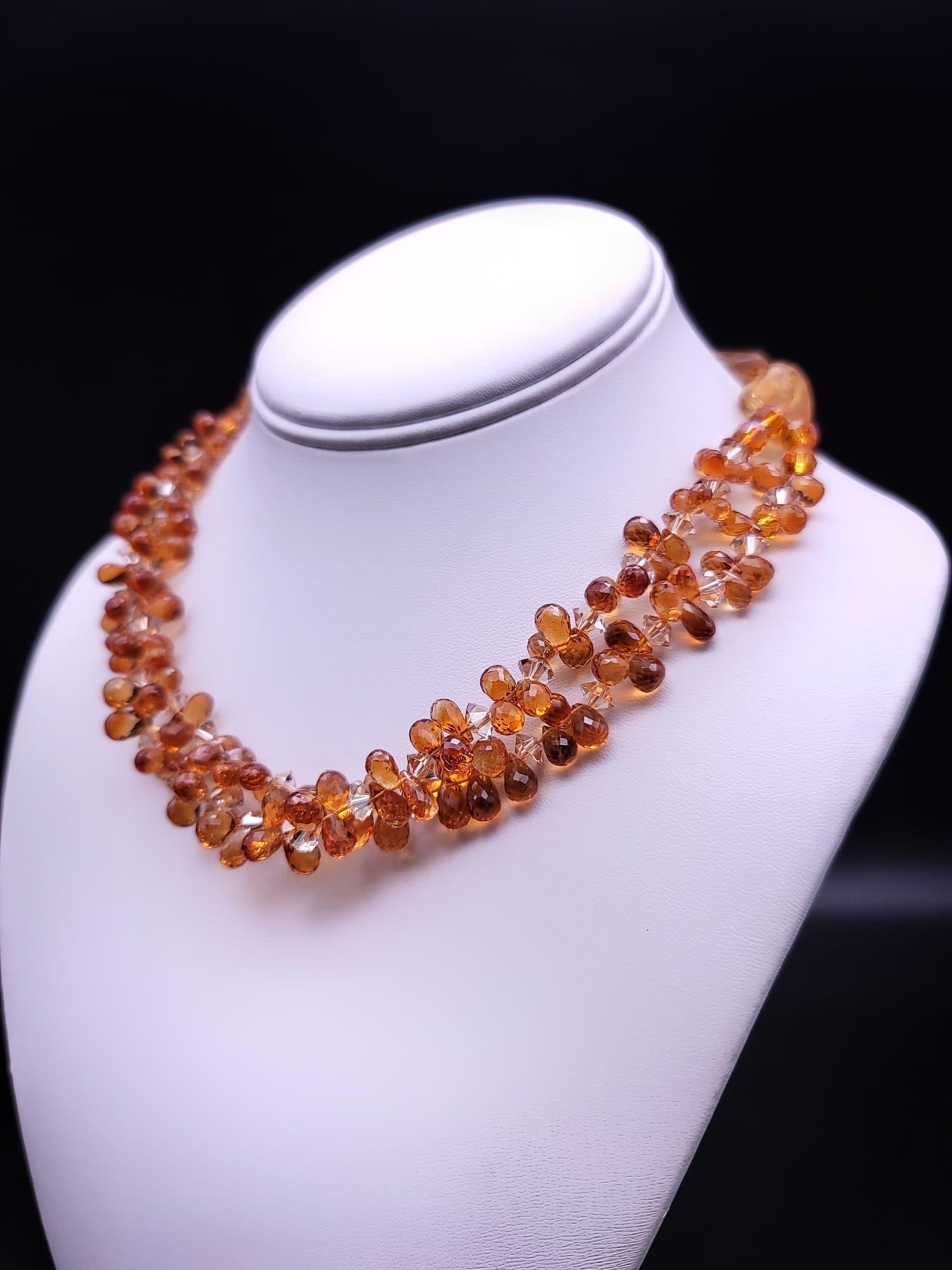 One-of-a-Kind

Two strands of richly colored, facetted Topaz teardrops mixed with a shade lighter Swarovski roundels form a ruffle around the neck caught by a single strand of sunstone and Topaz. The necklace is anchored by a polished Oak yellow