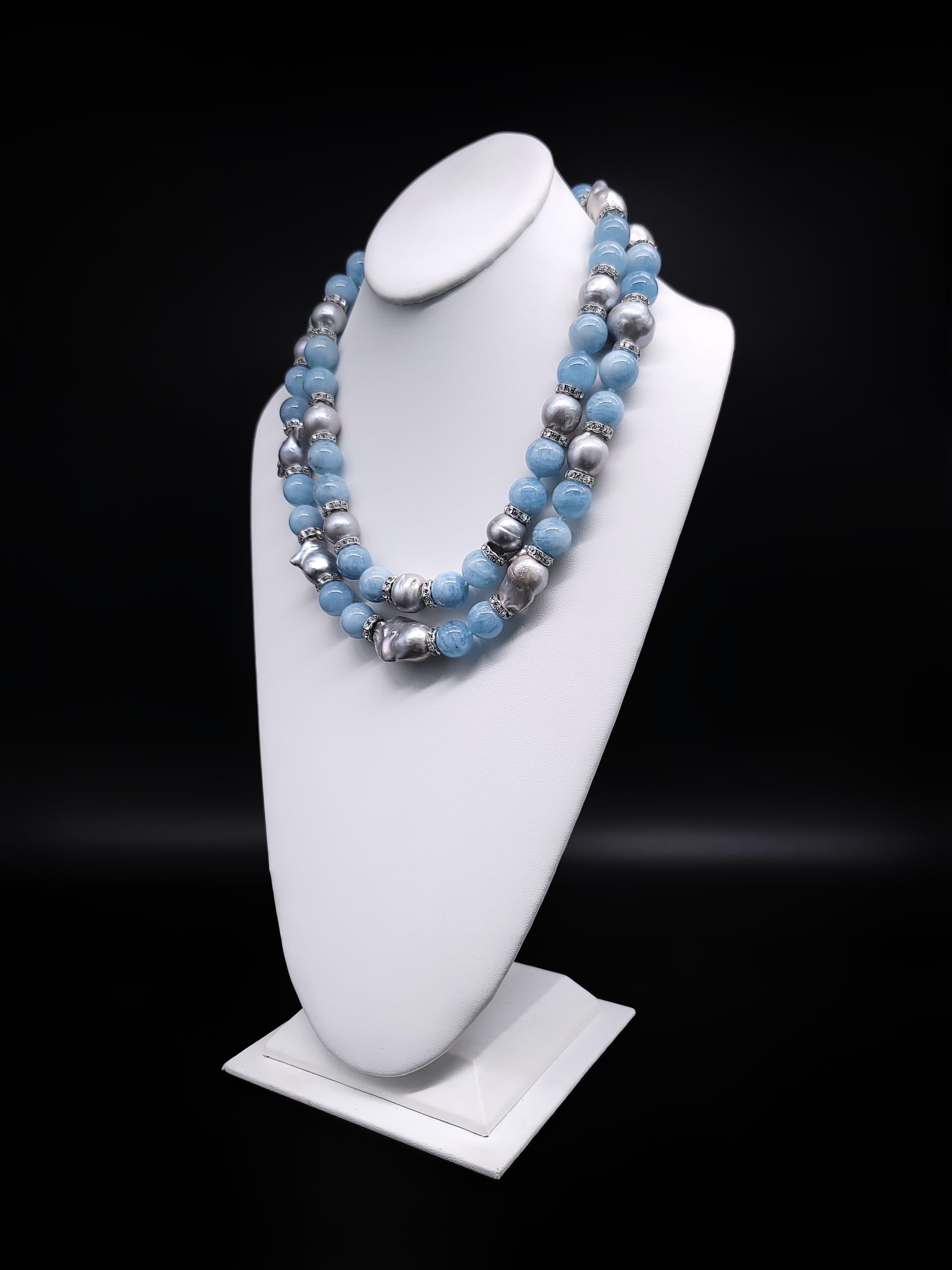 Exquisite Harmony:

Discover the extraordinary synergy of pale blue translucent Aquamarine (15-16mm) and lustrous Baroque Gray Pearls (16mm) in this exceptional two-strand necklace, adorned with CZ roundels set in sterling silver. This union of