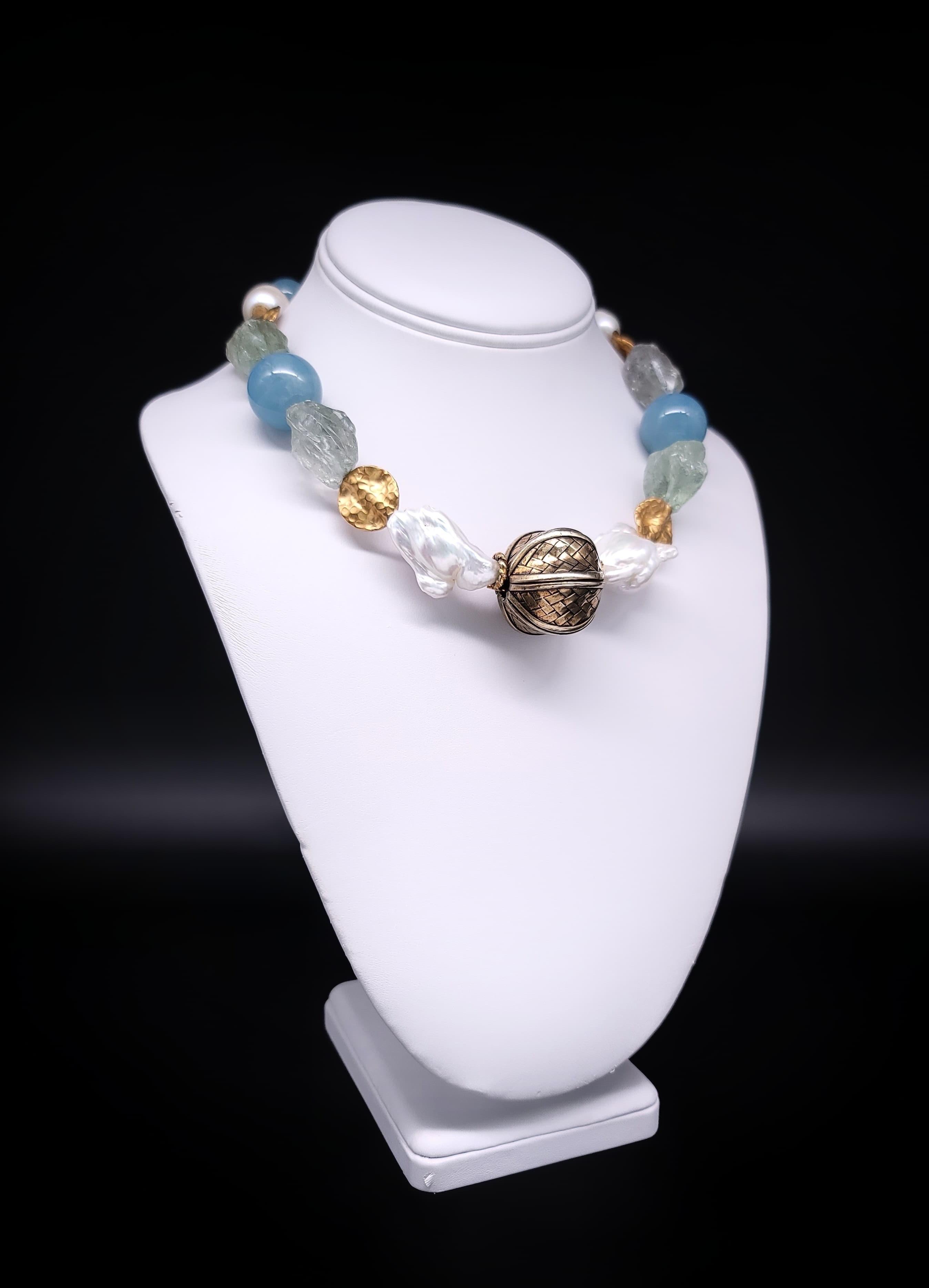 Diese mit viel Liebe zum Detail gefertigte, einzigartige Halskette ist ein Meisterwerk an Eleganz und Individualität. Das auffällige Design besticht durch eine faszinierende Mischung aus polierten 22-mm-Aquamarinperlen in verschiedenen Blautönen,