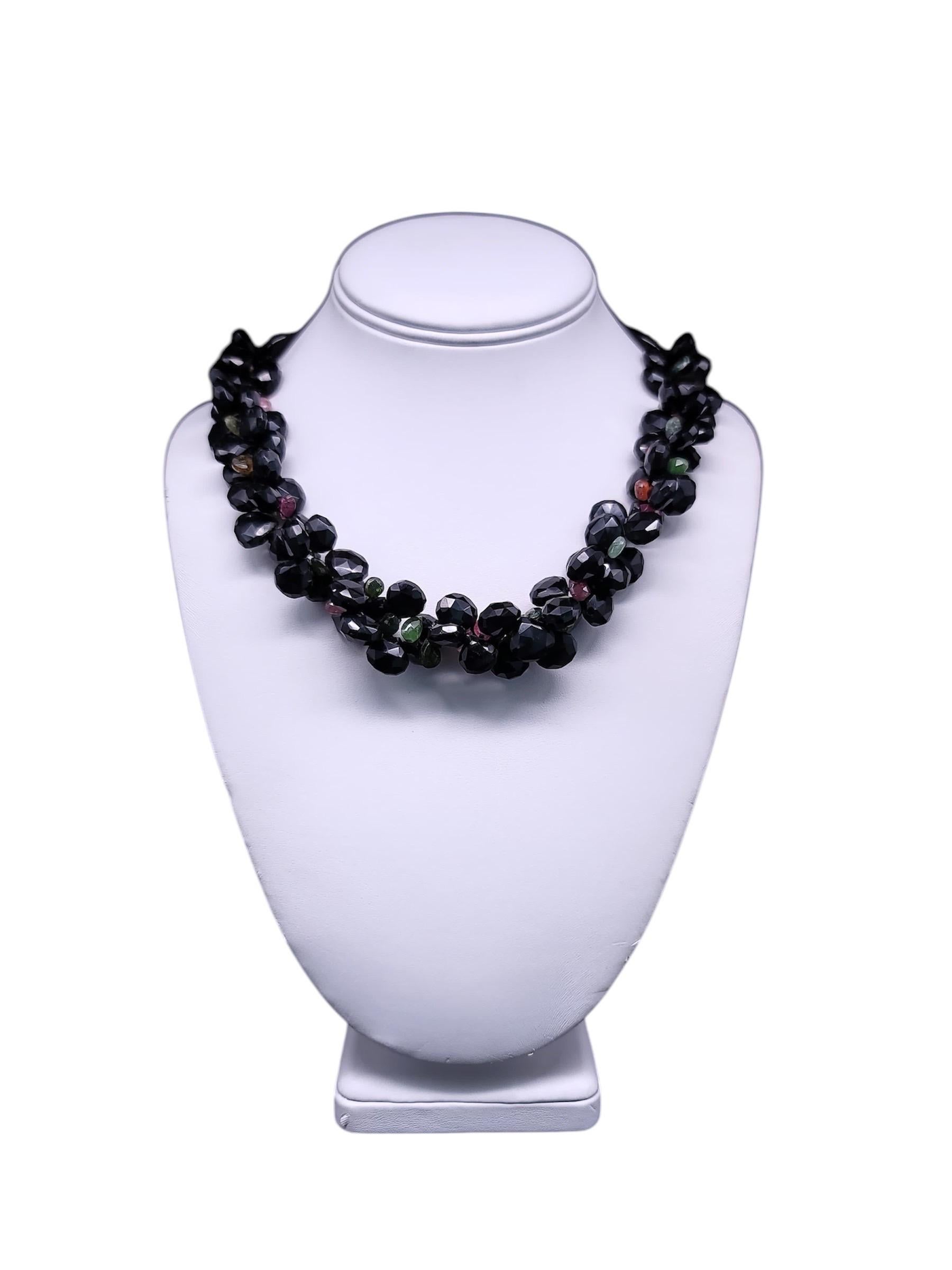 Ce collier unique en son genre est composé de grenats noirs facettés, d'onyx noir poli et de l'éclat subtil d'une tourmaline melon d'eau facettée. La couleur riche et profonde des grenats noirs scintille à chaque mouvement, ajoutant un éclat
