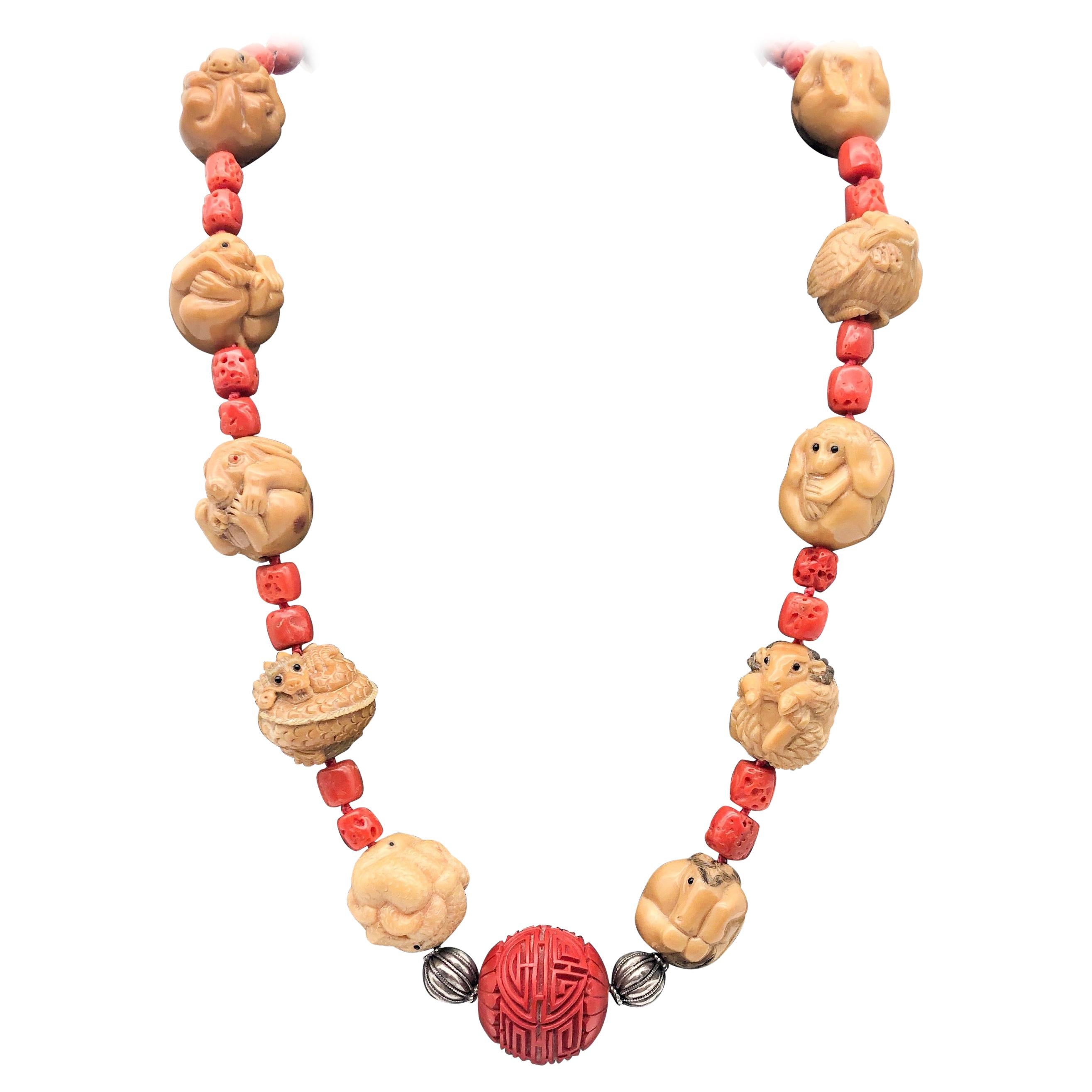 One-of-a-Kind

Carved and hand-tinted ox-bone animal of the Chinese zodiac necklace.
 Centered by a large vintage carved Cinnabar bead separated by sterling silver balls all twelve animals are represented (from rat to pig). Each has been carved