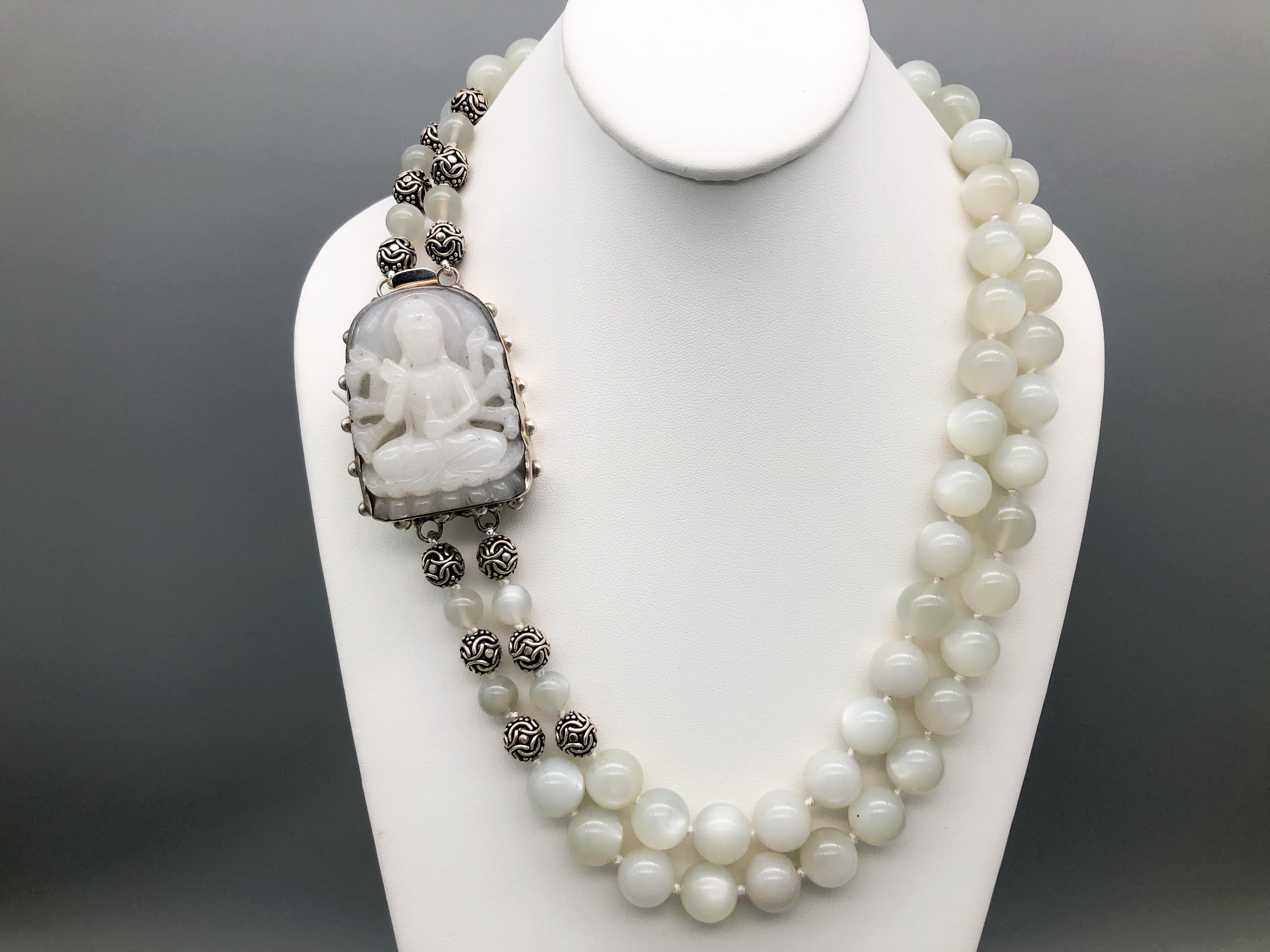 One-of-a-Kind
The beautiful Goddess of Compassion Guan Yin carved from Moonstone sits regally on her lotus leaf, her many arms reaching out to give help, surrounded by a double strand of shimmering 14 mm Moonstone and Sterling Silver. The heavily