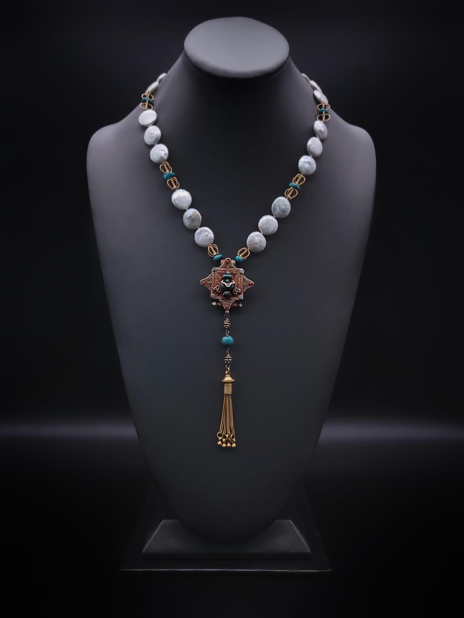 One-of-a-Kind

A delicate necklace of coin Pearls, Turquoise, and vermeil spacers complement the lovely Ghau box it encircles. Ghau box is a precious hand-crafted amulet, usually made in a Tibetan monastery, as this one is.
Traditionally worn around
