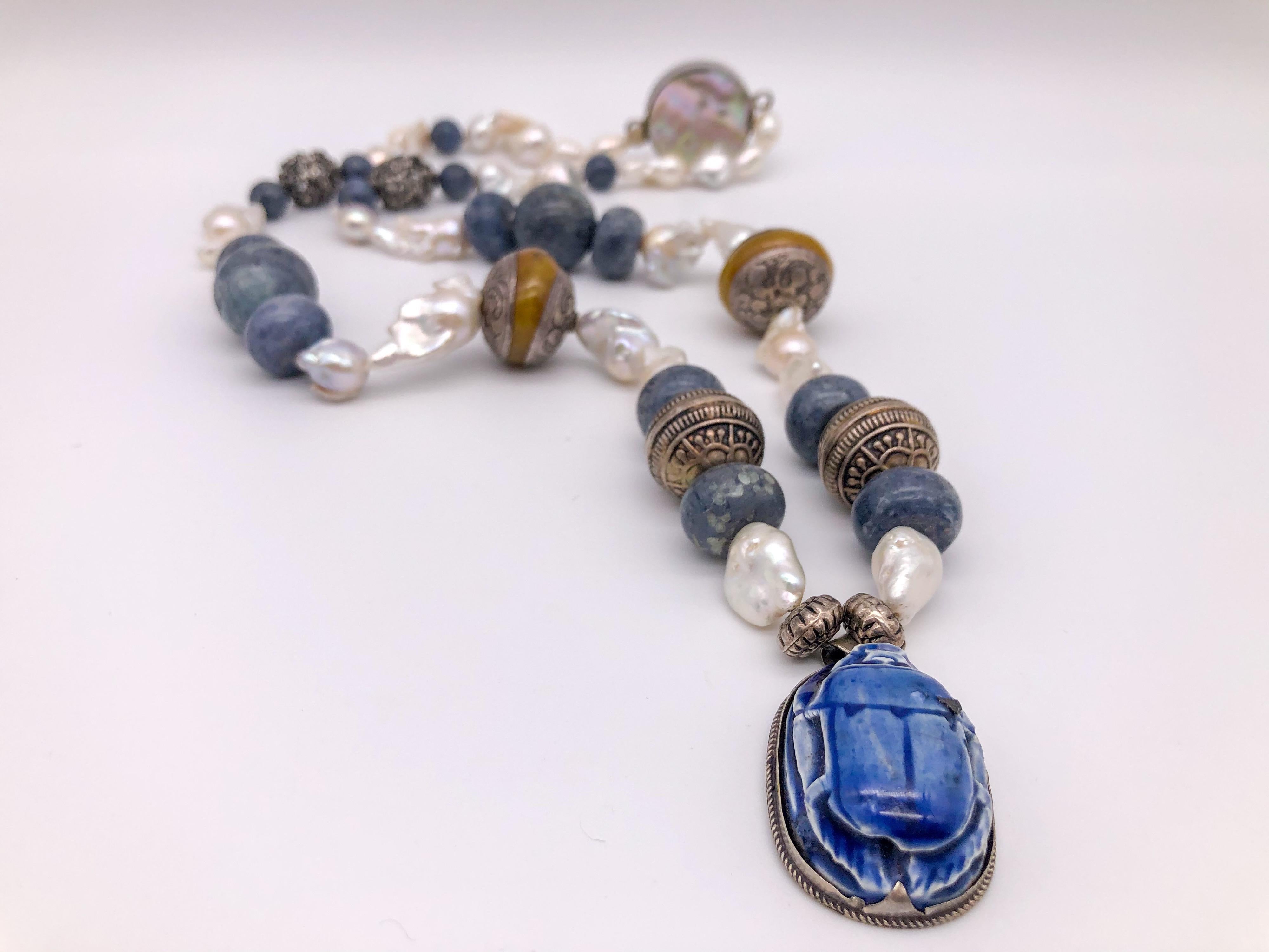 One-of-a-Kind
This 30” long necklace is an embarrassment of treasures. Let us start with the symbol of rebirth ( fresh hope) the large ceramic scarab, next to a pair of heavily embossed Sterling Silver beads, followed by a pair of Tibetan silver and