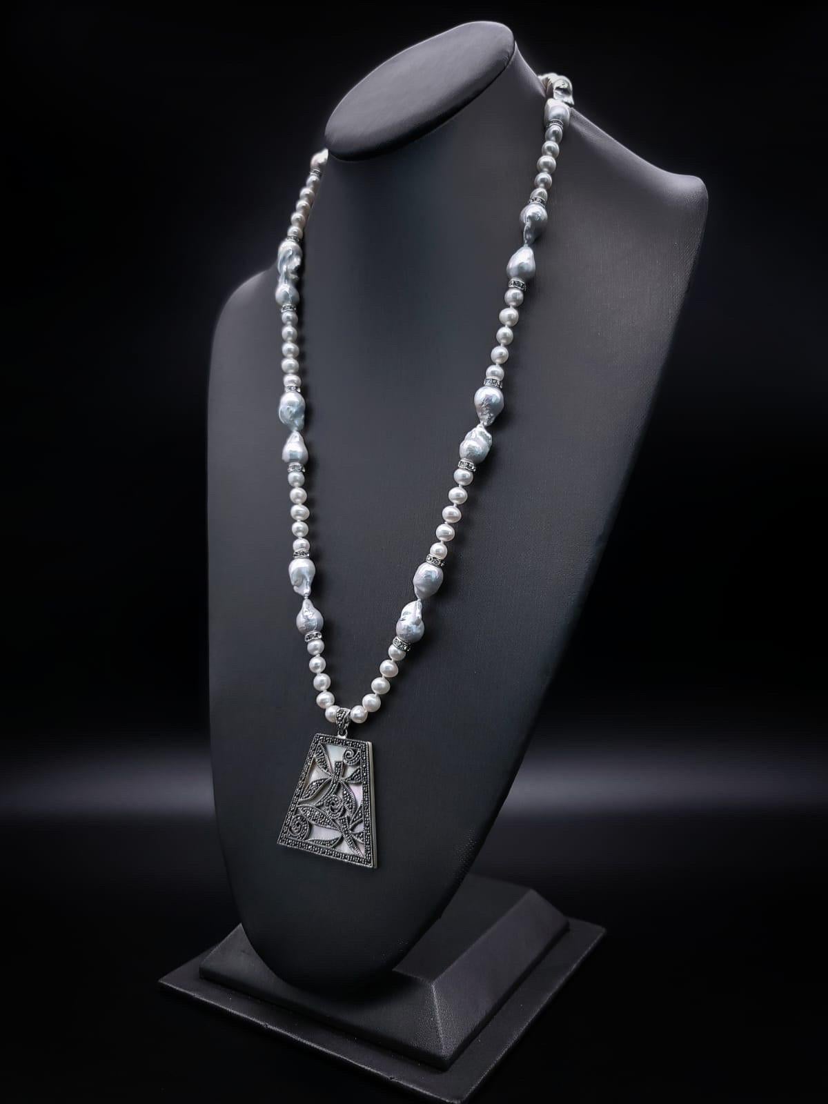 One-of-a-Kind

A fresh take on Marcasite, in a newly designed pendant set on Mother-of-Pearl in the deco style. The pendant is suspended from a 36’’ strand of Baroque Pearls interspersed with 5 m.m pearls and CZ roundels. Finished with a silvery