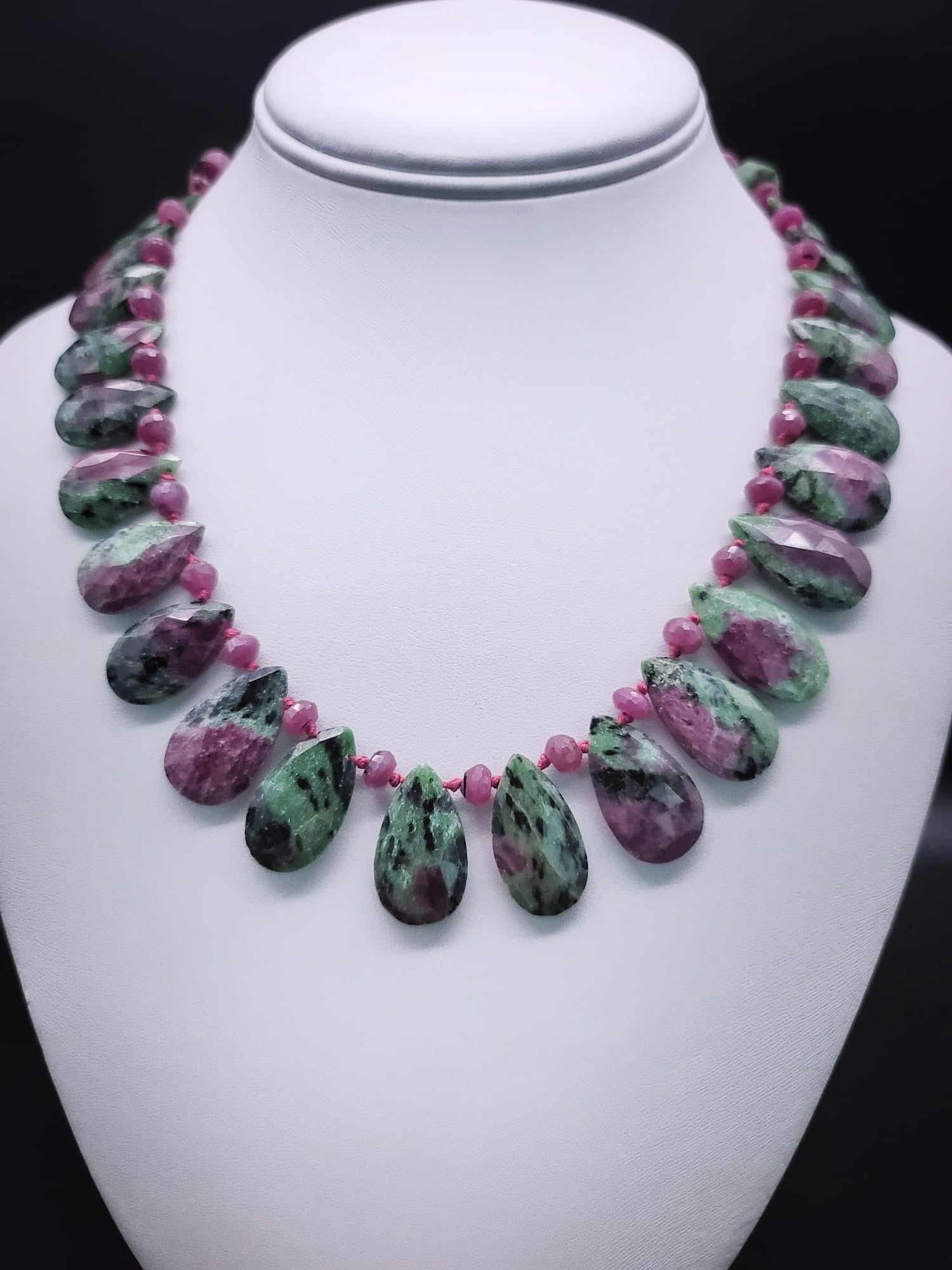 One-of-a-Kind

Elegant Ruby Zoisite faceted teardrops are matched to facetted ruby roundels
to create a richly flattering necklace. The back of the necklace is the same ruby zoisite stone cut as beads to ensure a comfortable fit. The clasp is a 