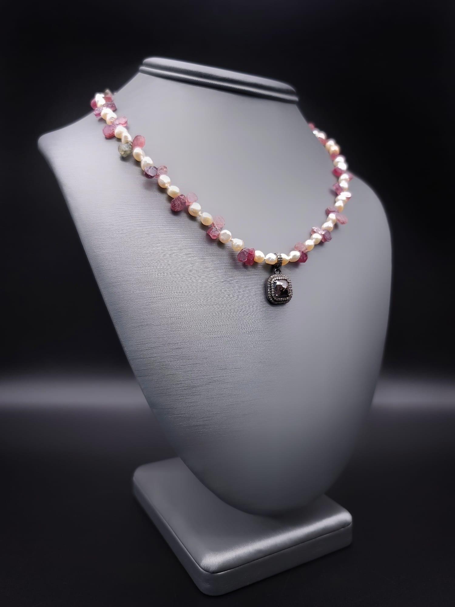 One-of-a-Kind

An elegantly romantic single-strand necklace 4m.m Pearls  
Interspersed between twin Pink Sapphire teardrops surrounding a delicate pendant of two rows of diamonds surrounding a square faceted ruby. The clasp is a sterling silver box