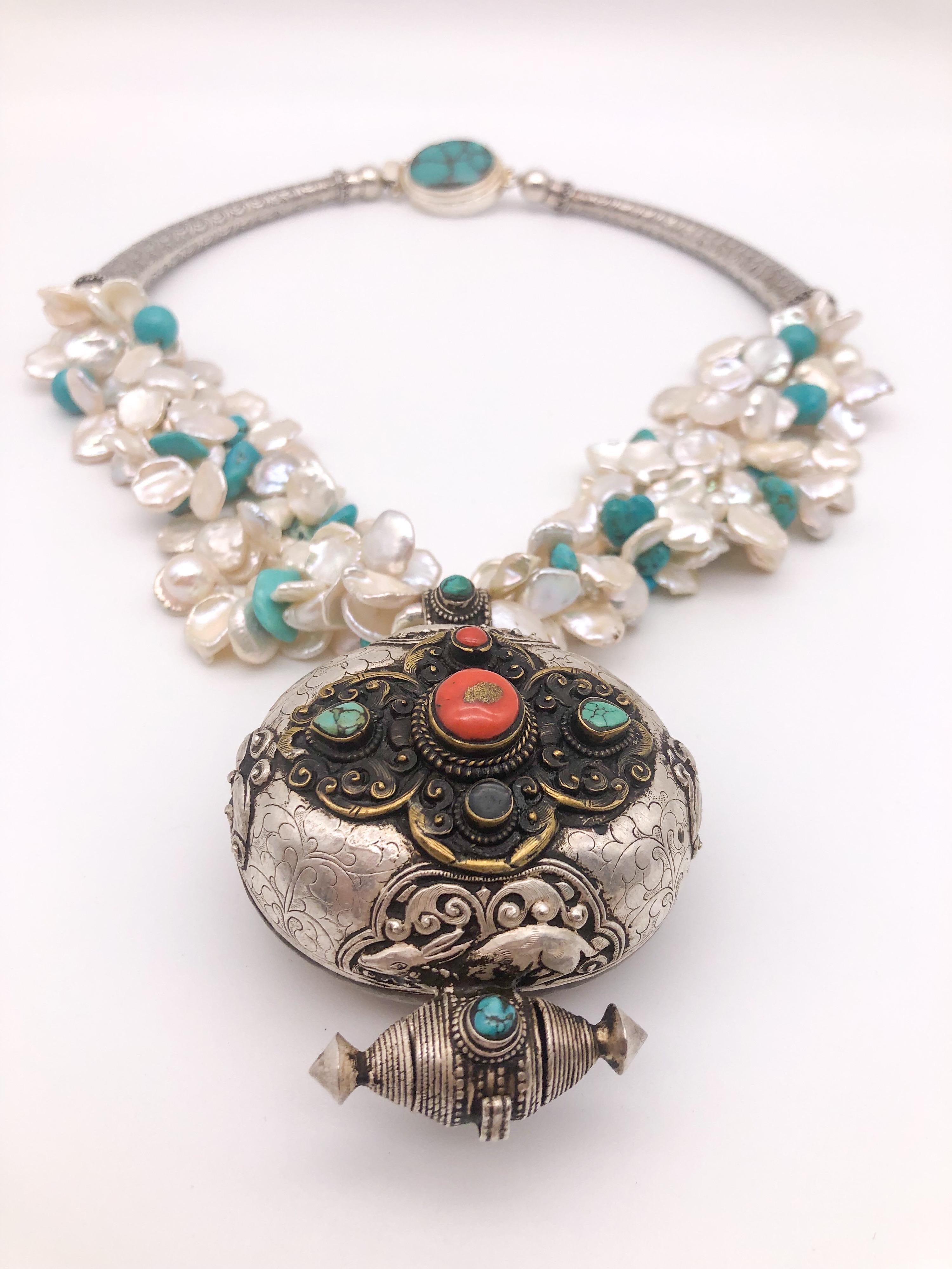 One-of-a-Kind
Multi-strand freshwater Keshi Pearl and Turquoise necklace with a fine quality oval Tibetan Ghau Prayer Box surrounded by smaller turquoise and coral. This piece is handcrafted from hand-hammered Sterling Silver with a copper back. The
