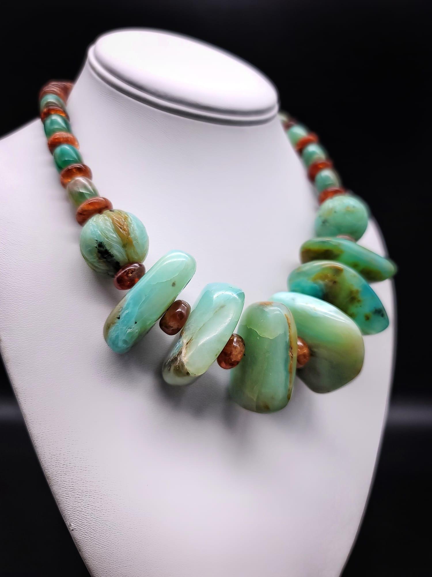 One-of-a-Kind

Magnificent Peruvian opal necklace, each of the six polished center stones is a large polished specimen in a different shade. The opals are separated by hessonite ( brown garnets)rondels., a  translucent stone that mimics the color of